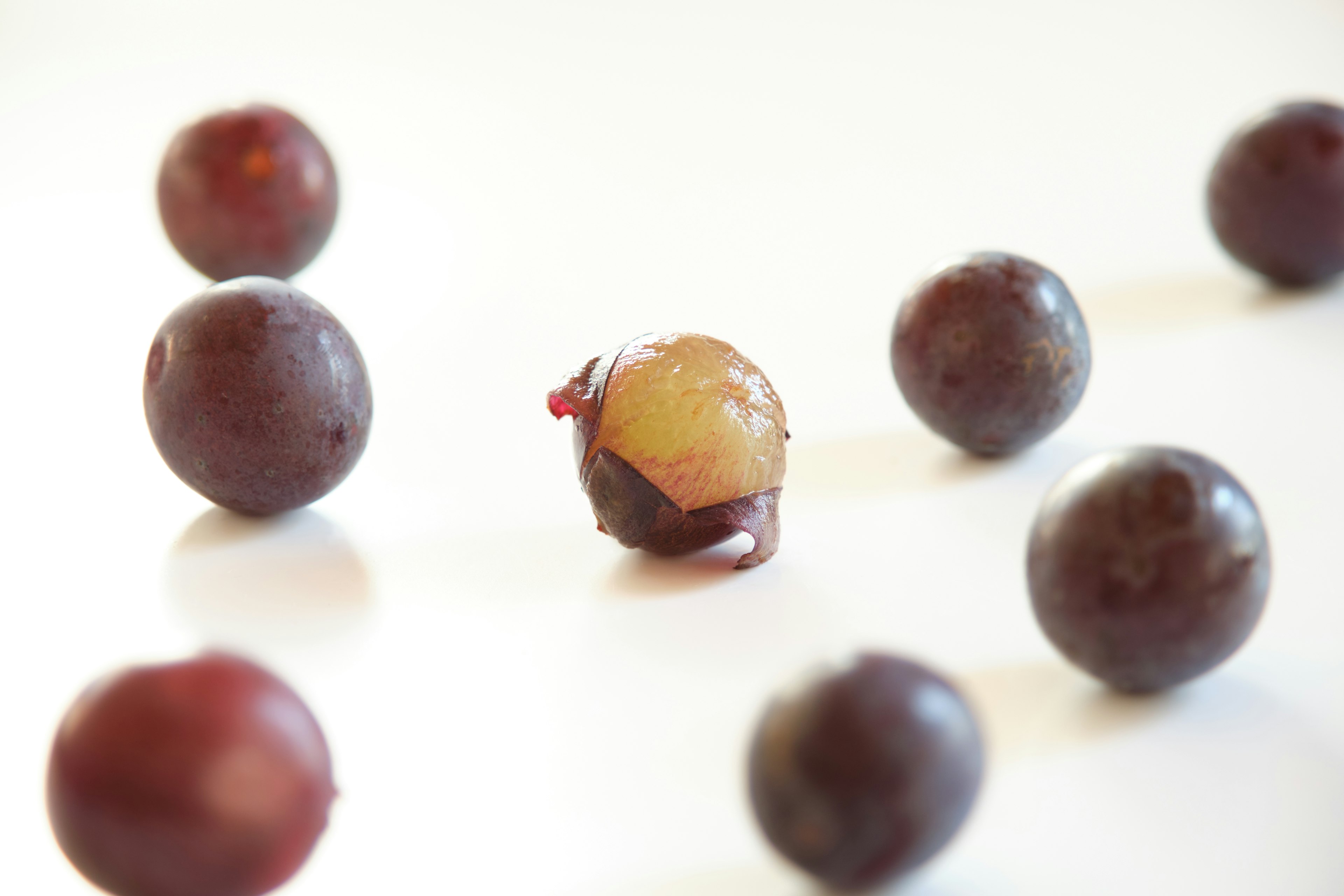 A halved grape in the center surrounded by whole grapes