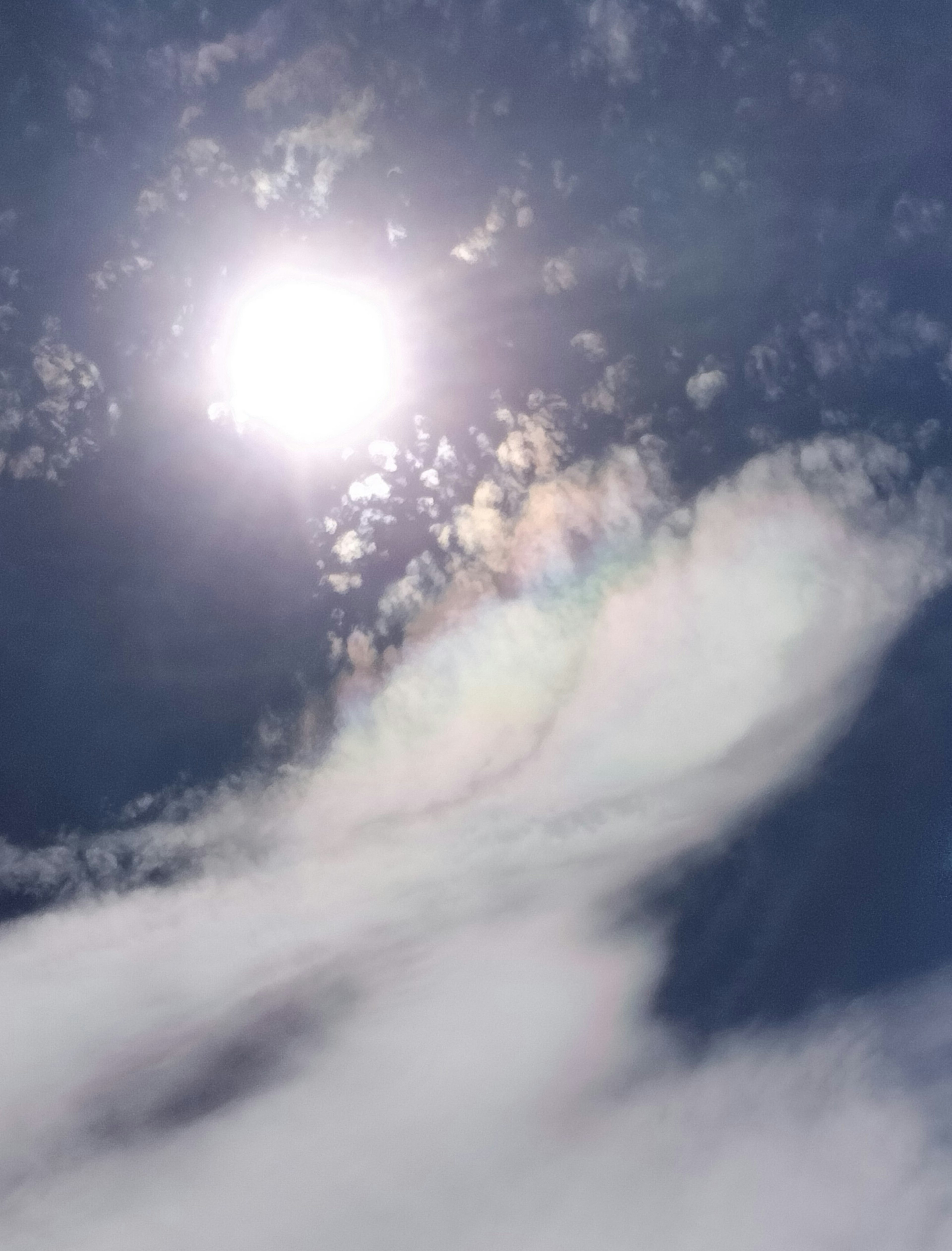 Helle Sonnenstrahlen, die durch Wolken in einem blauen Himmel scheinen