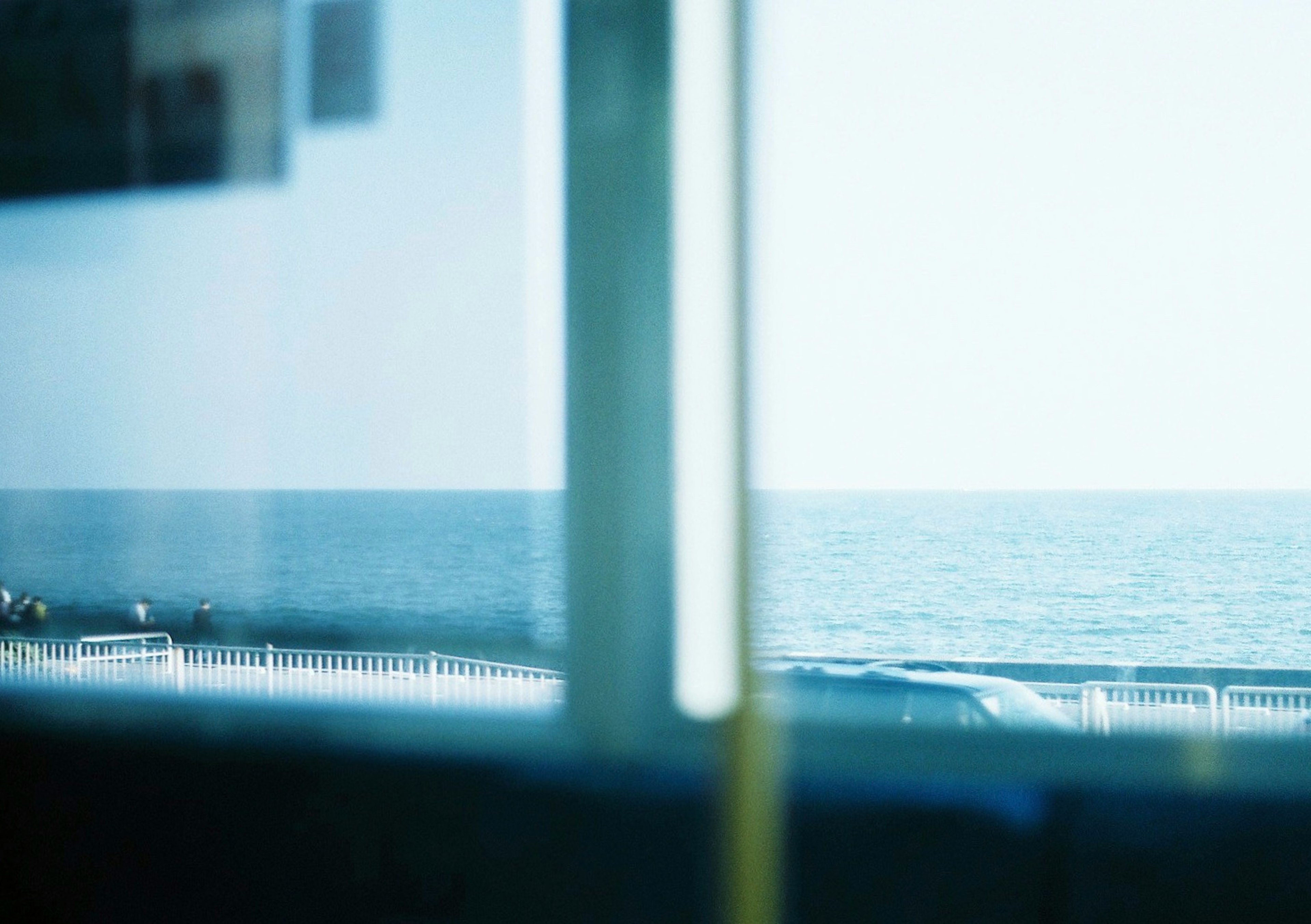 View of the ocean and blue sky through a window