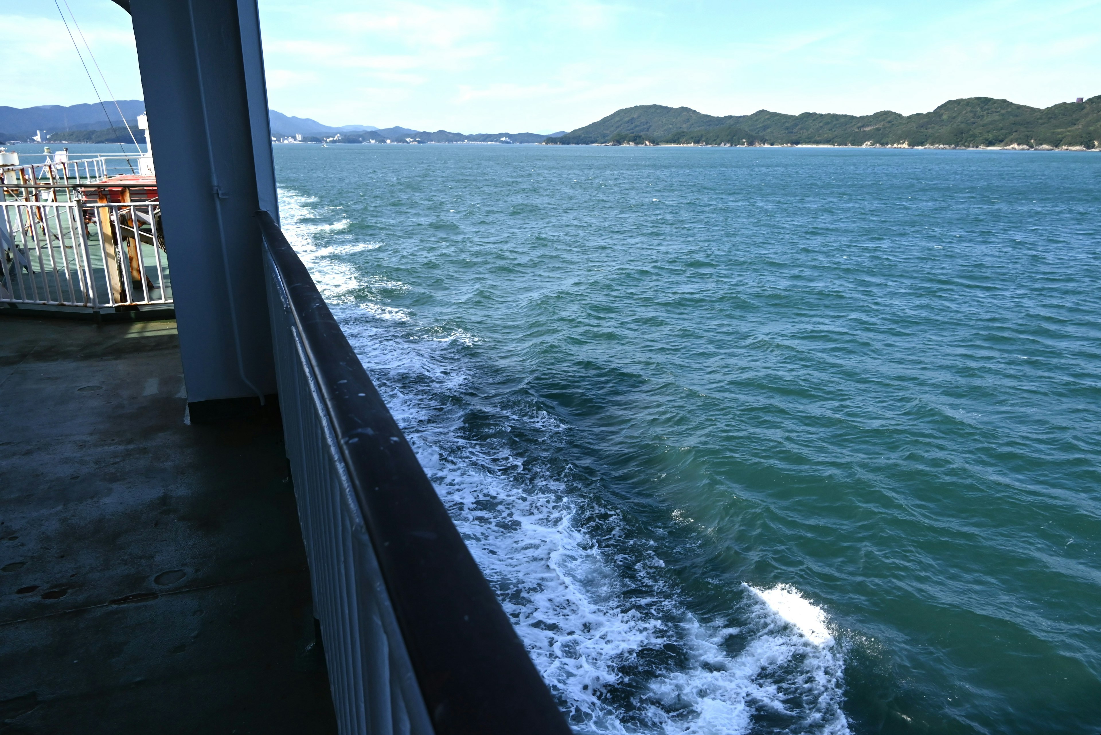 Pont d'un bateau avec des vagues océaniques et des montagnes au loin