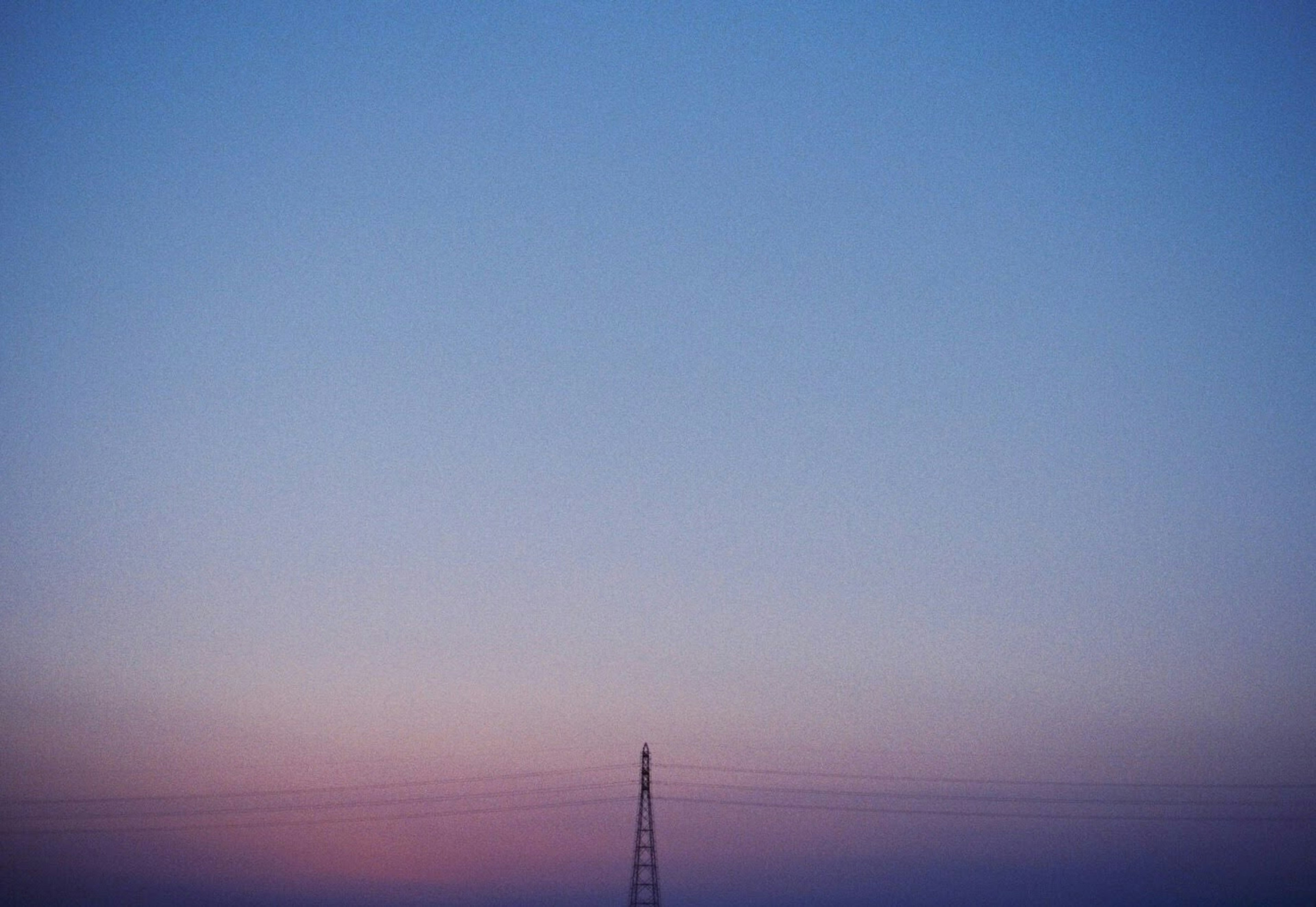 Verlaufshimmel mit blauen und sanften rosa Tönen mit einem Sendemast