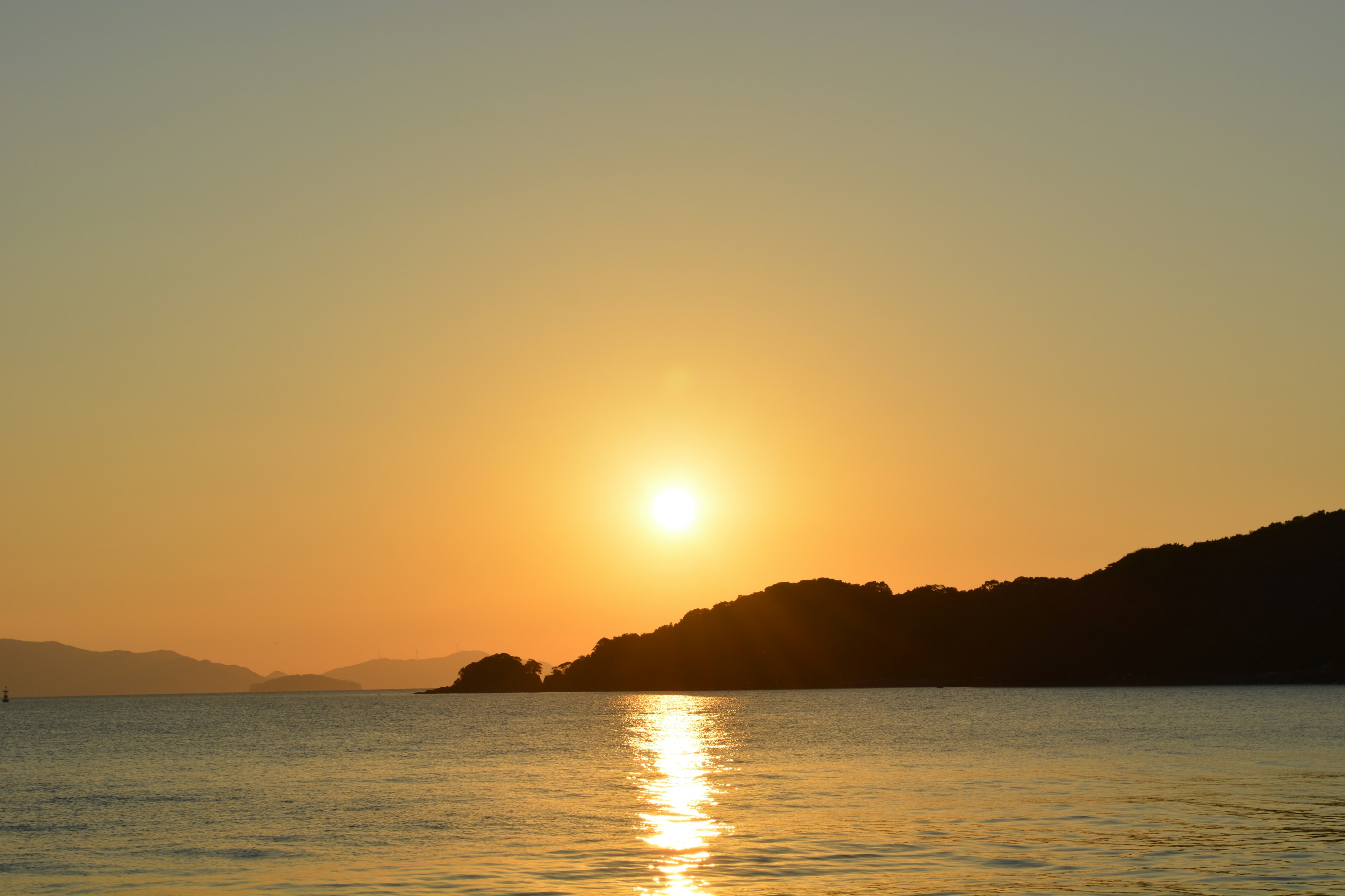 Puesta de sol sobre el mar con siluetas de islas