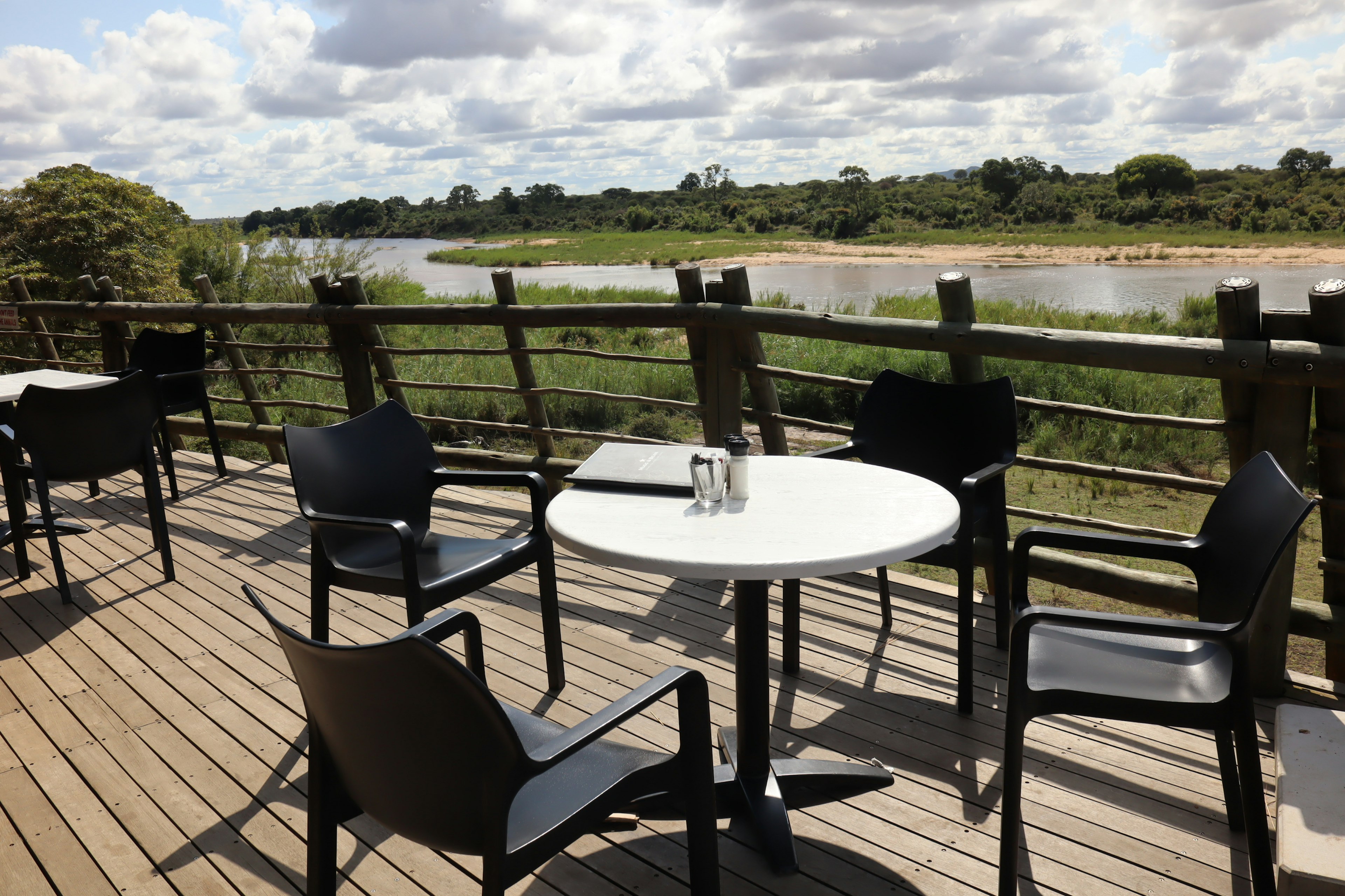 Table and chairs on a terrace overlooking a river landscape