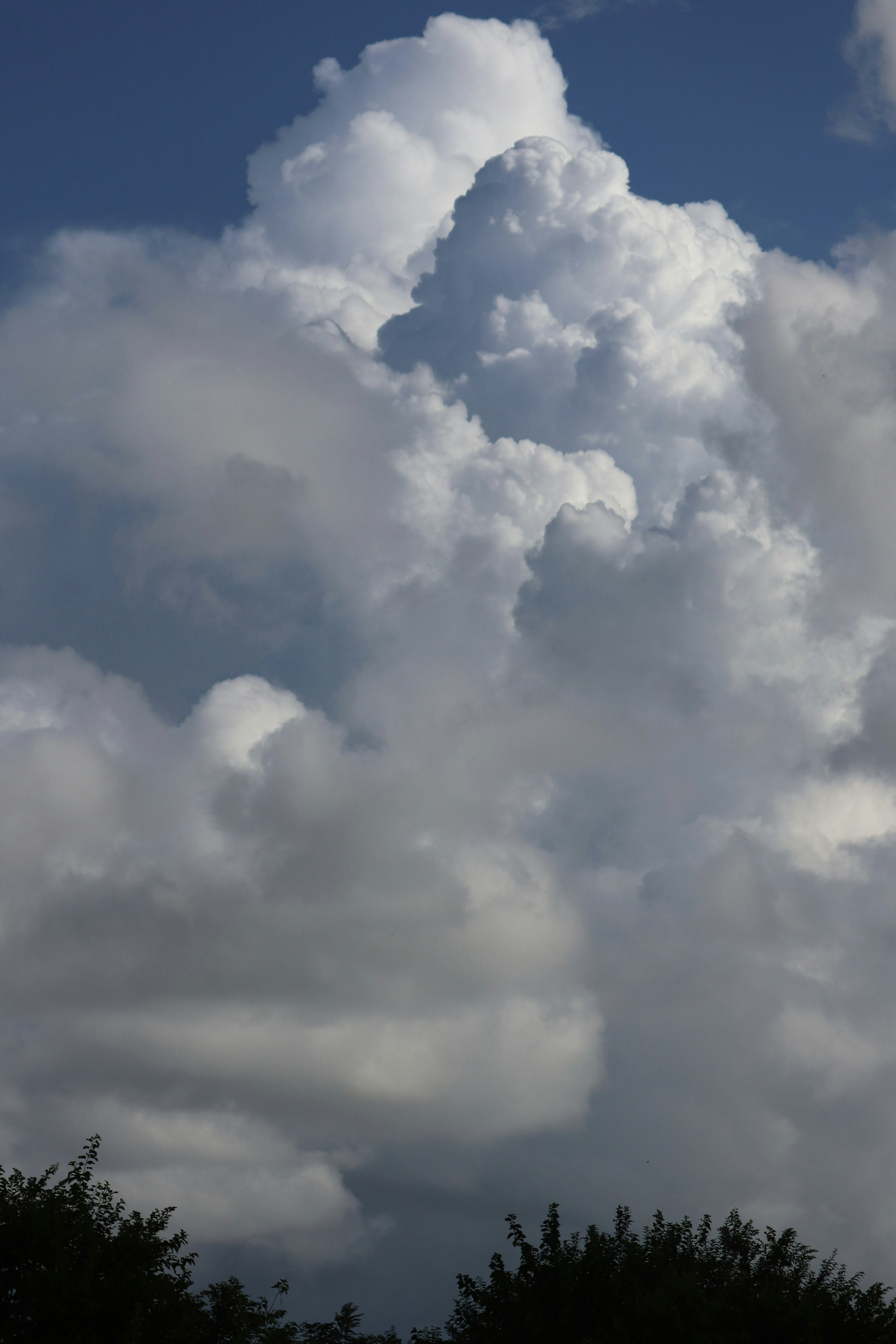 Gestapelte weiße Wolken vor blauem Himmel