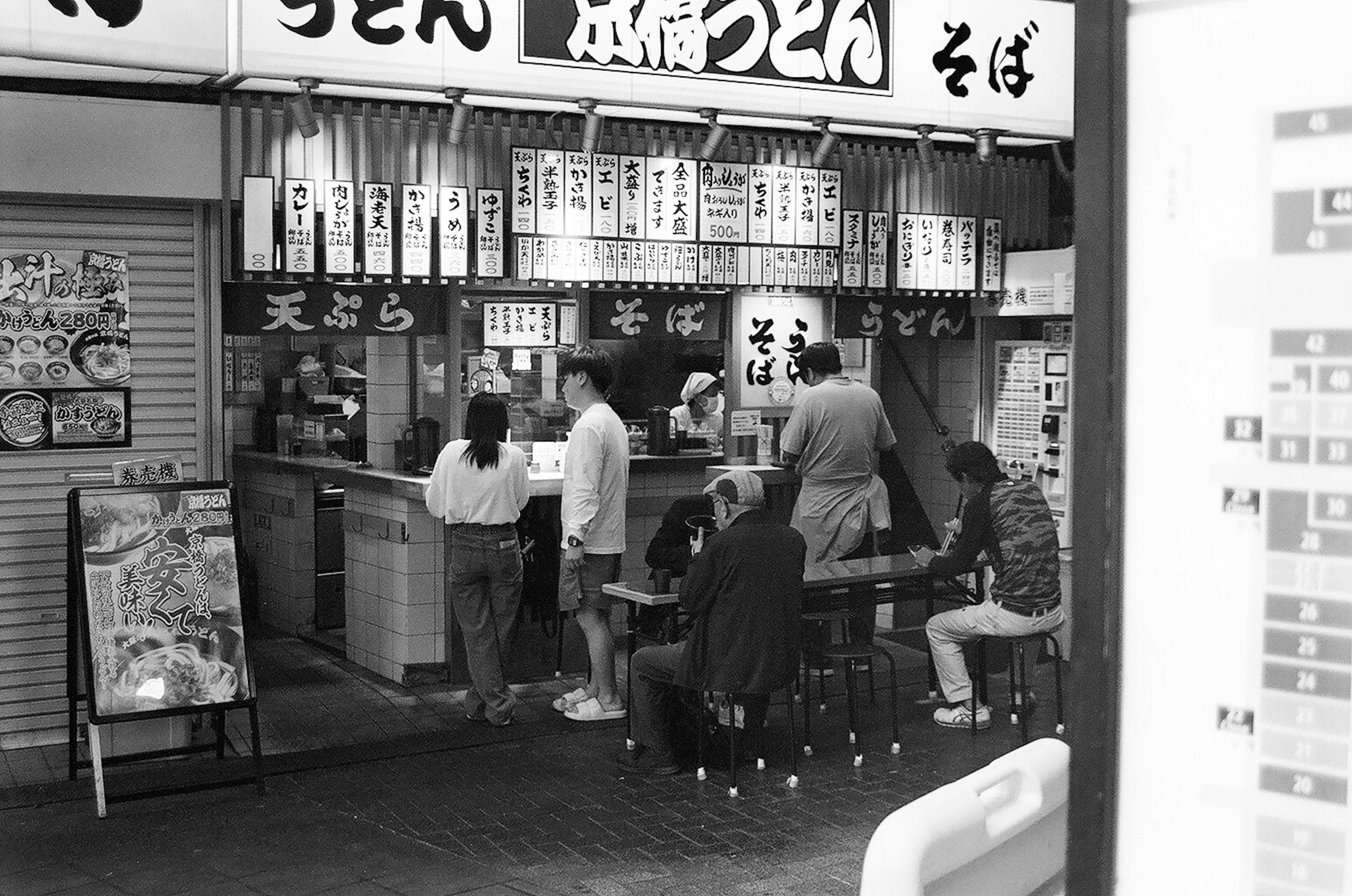 Black and white image of a udon shop with customers dining