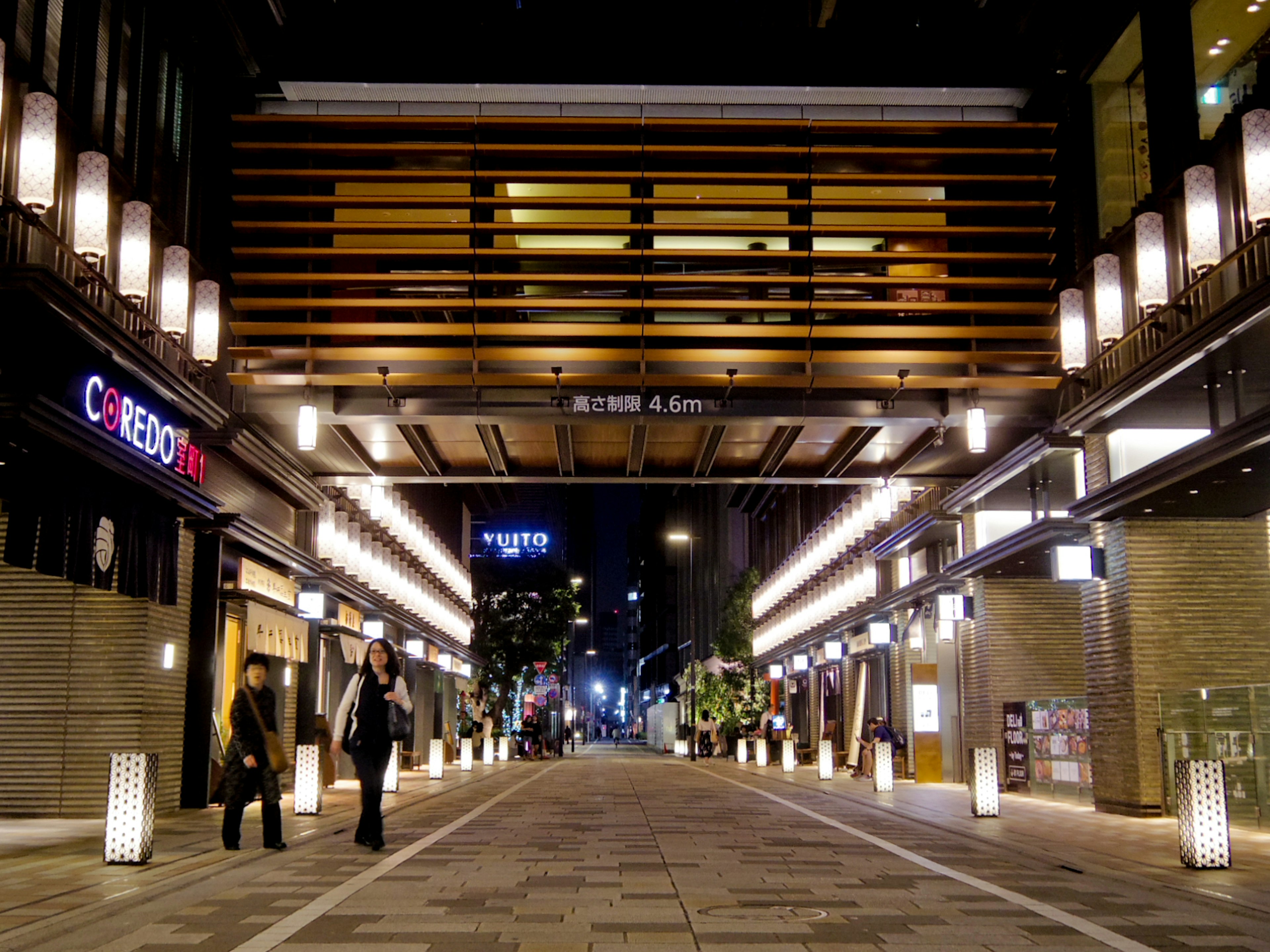 A beautifully lit street scene at night with modern architecture