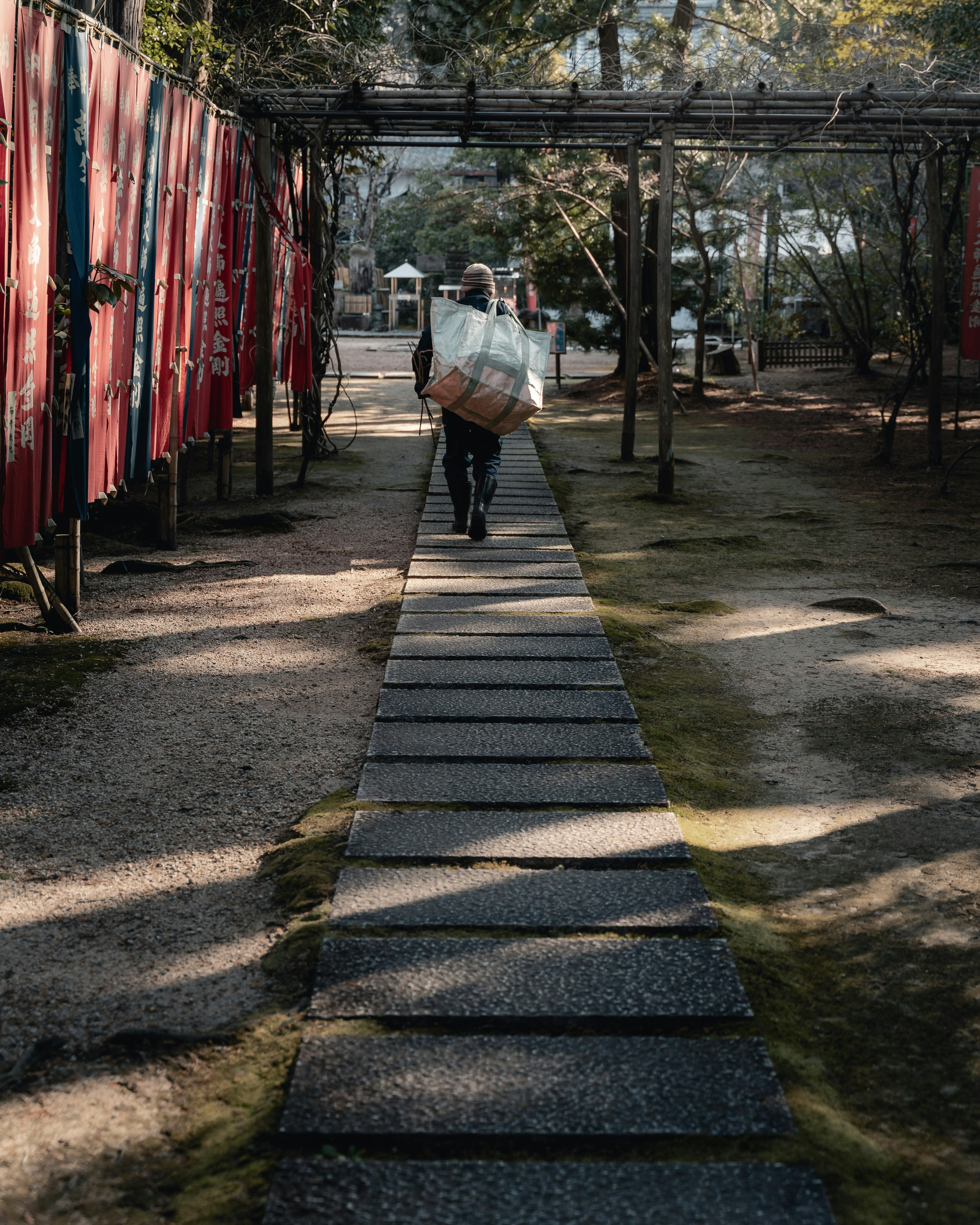 在石頭路上行走的人與紅色布料背景