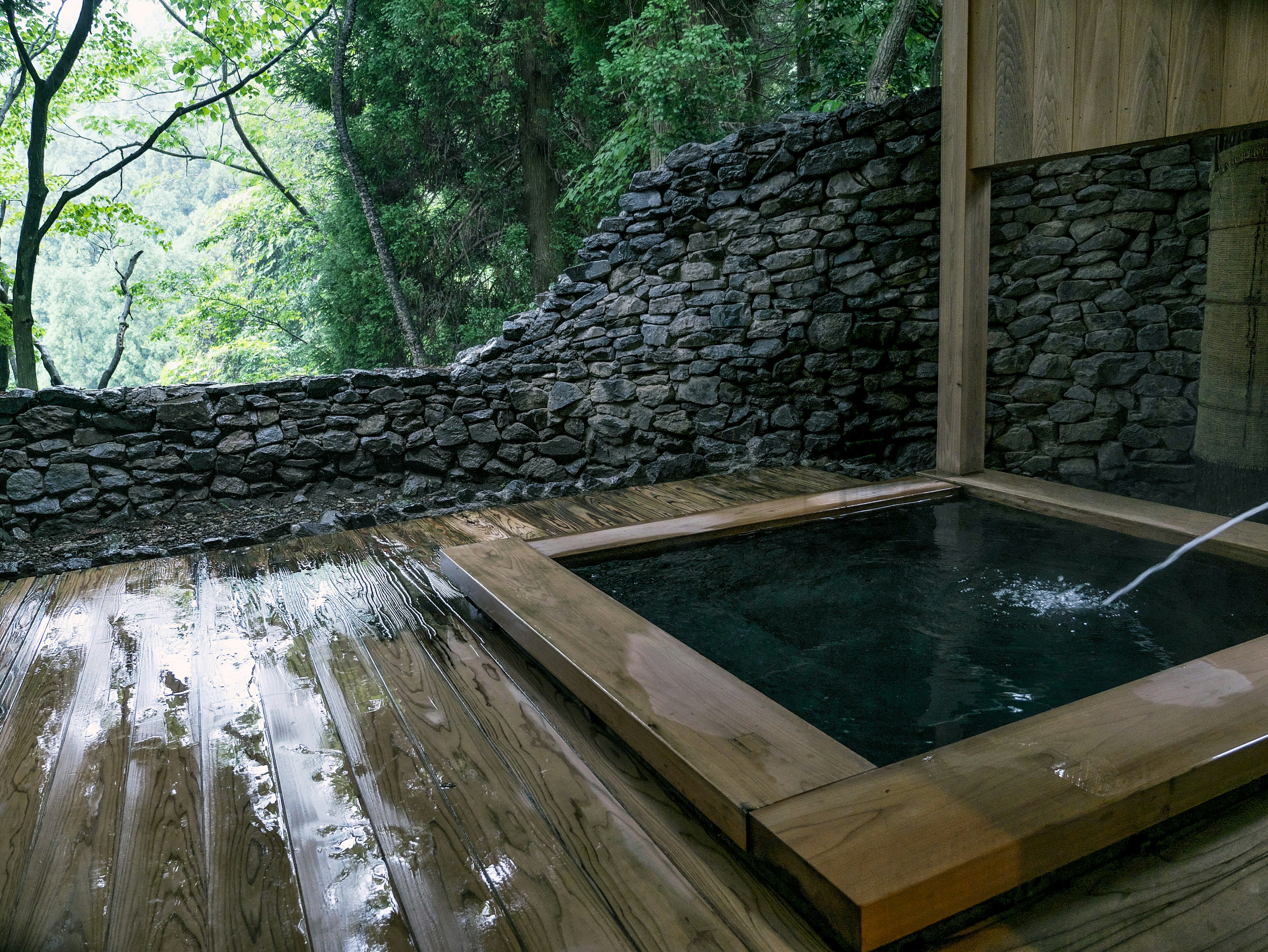 Hot spring tub set on a wooden deck surrounded by nature