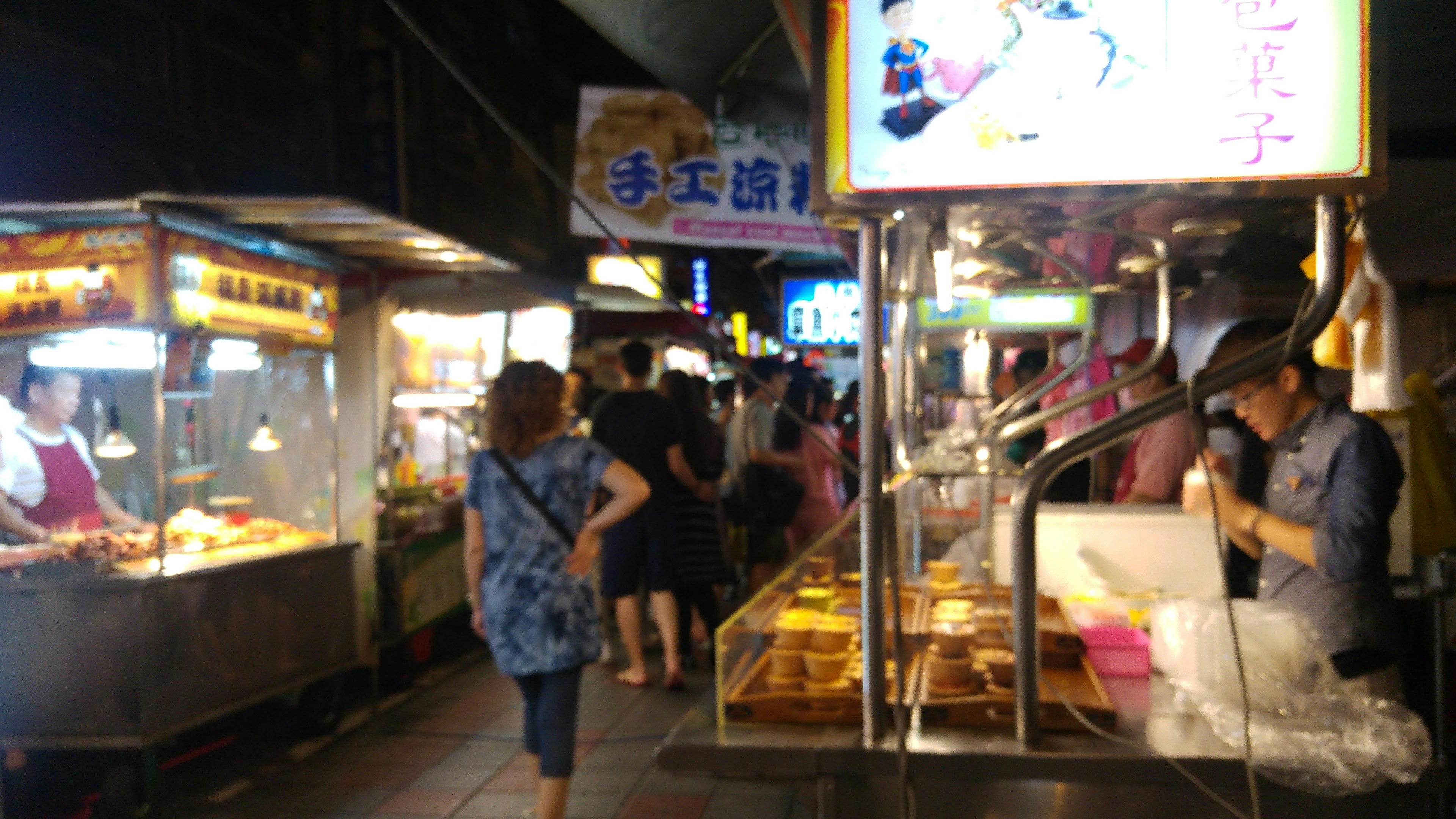 热闹的夜市场景，有食品摊位和人群