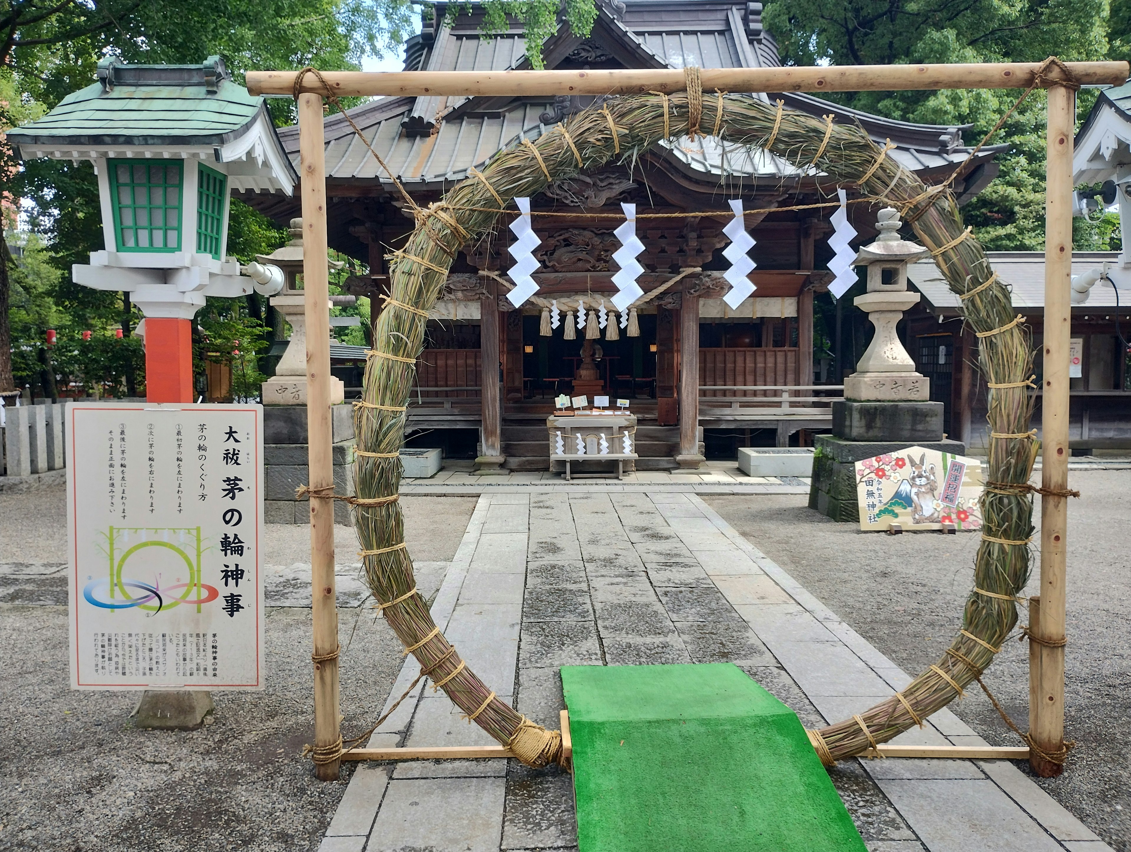 A large straw ring at the entrance of a shrine with a green carpet