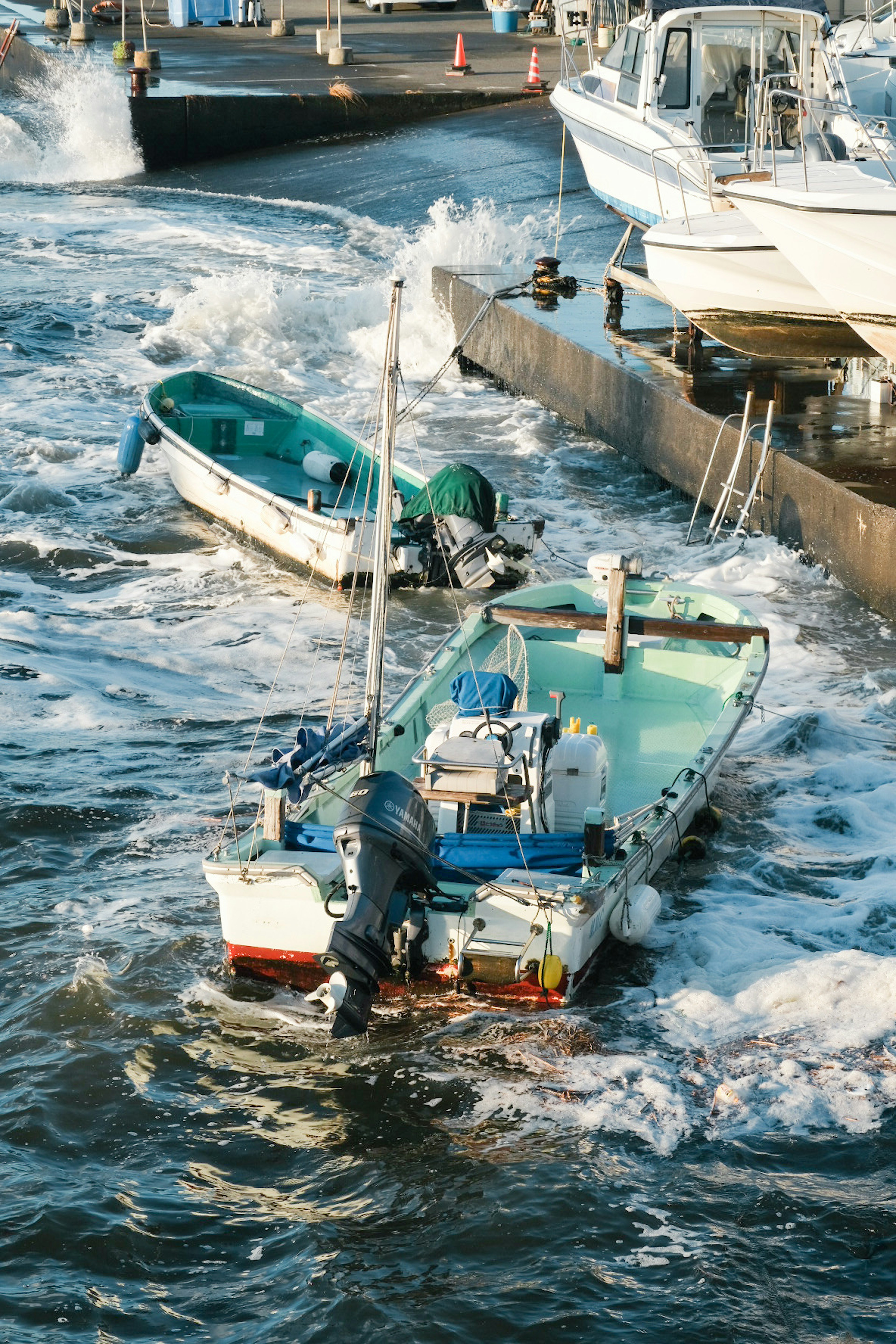 Small boats bobbing in the waves at the dock