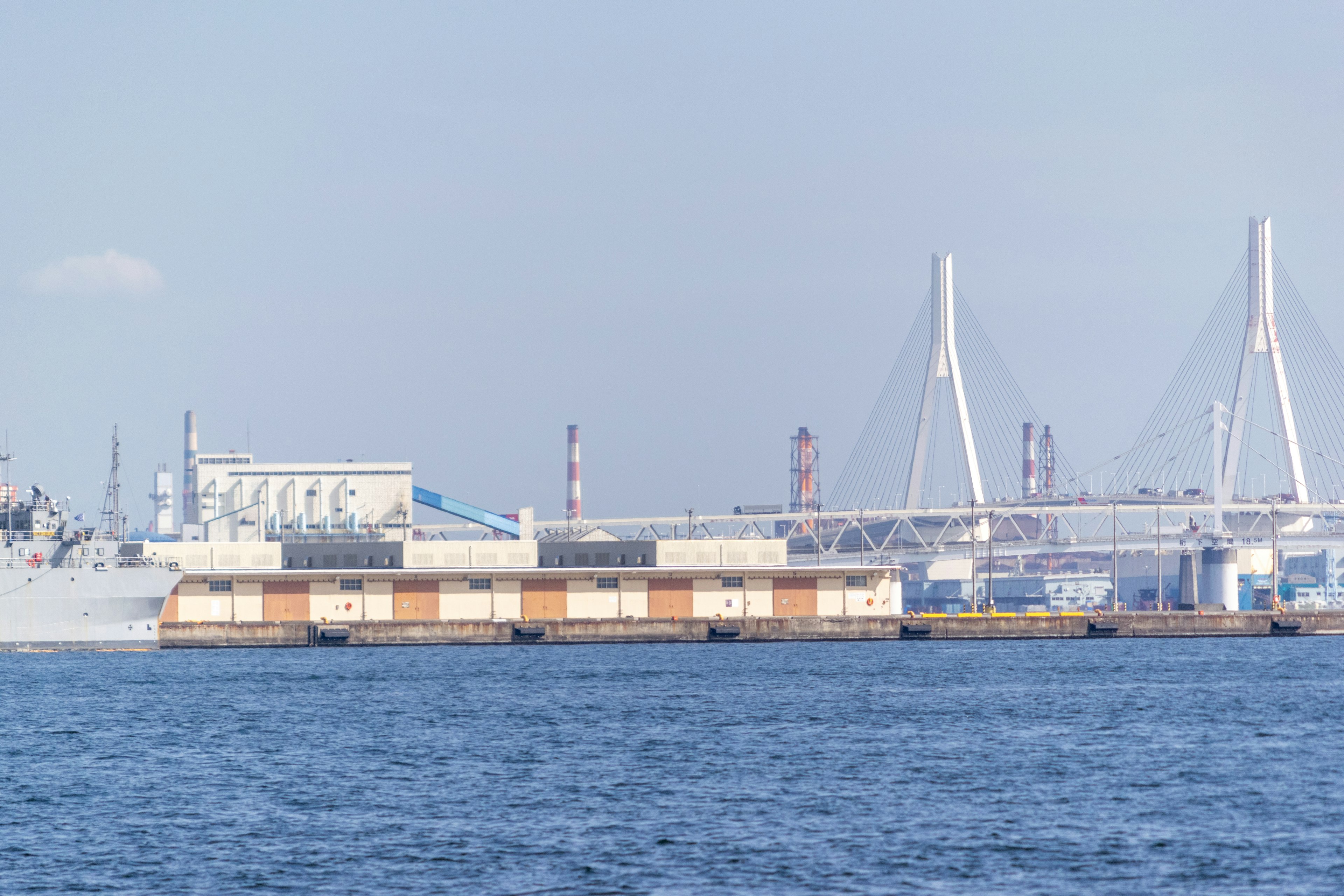 Ein Frachtschiff auf dem Wasser mit einer Brücke im Hintergrund