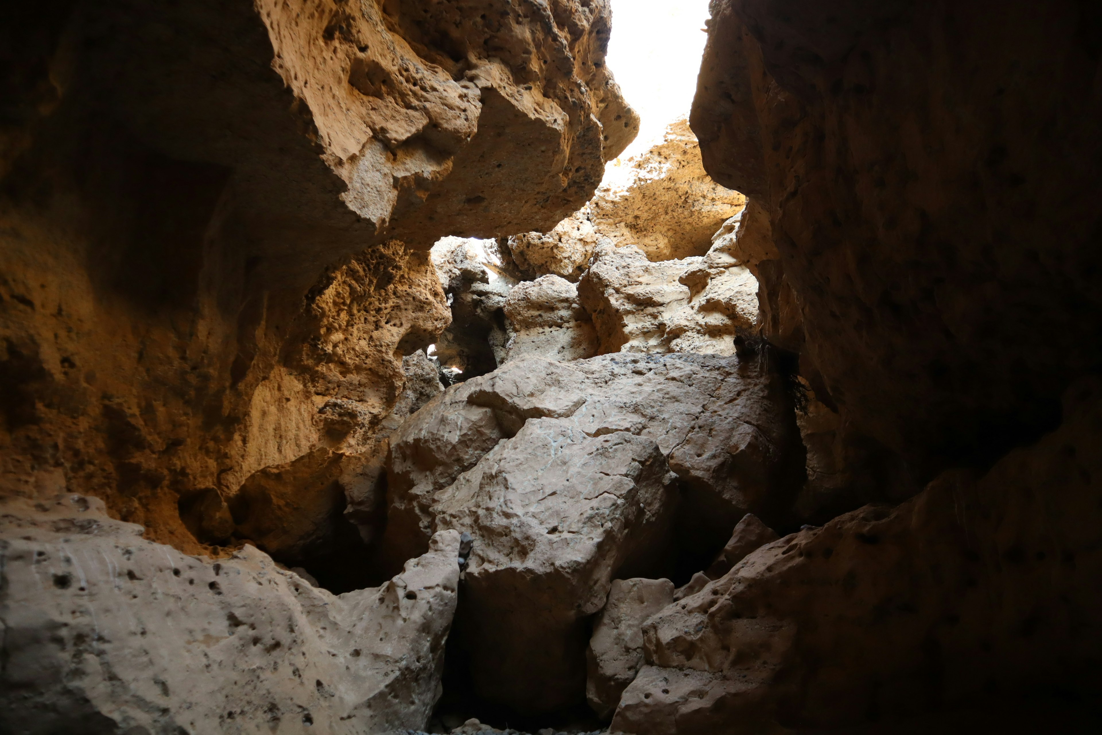 Lumière vive visible à travers des crevasses rocheuses et des formations rocheuses irrégulières