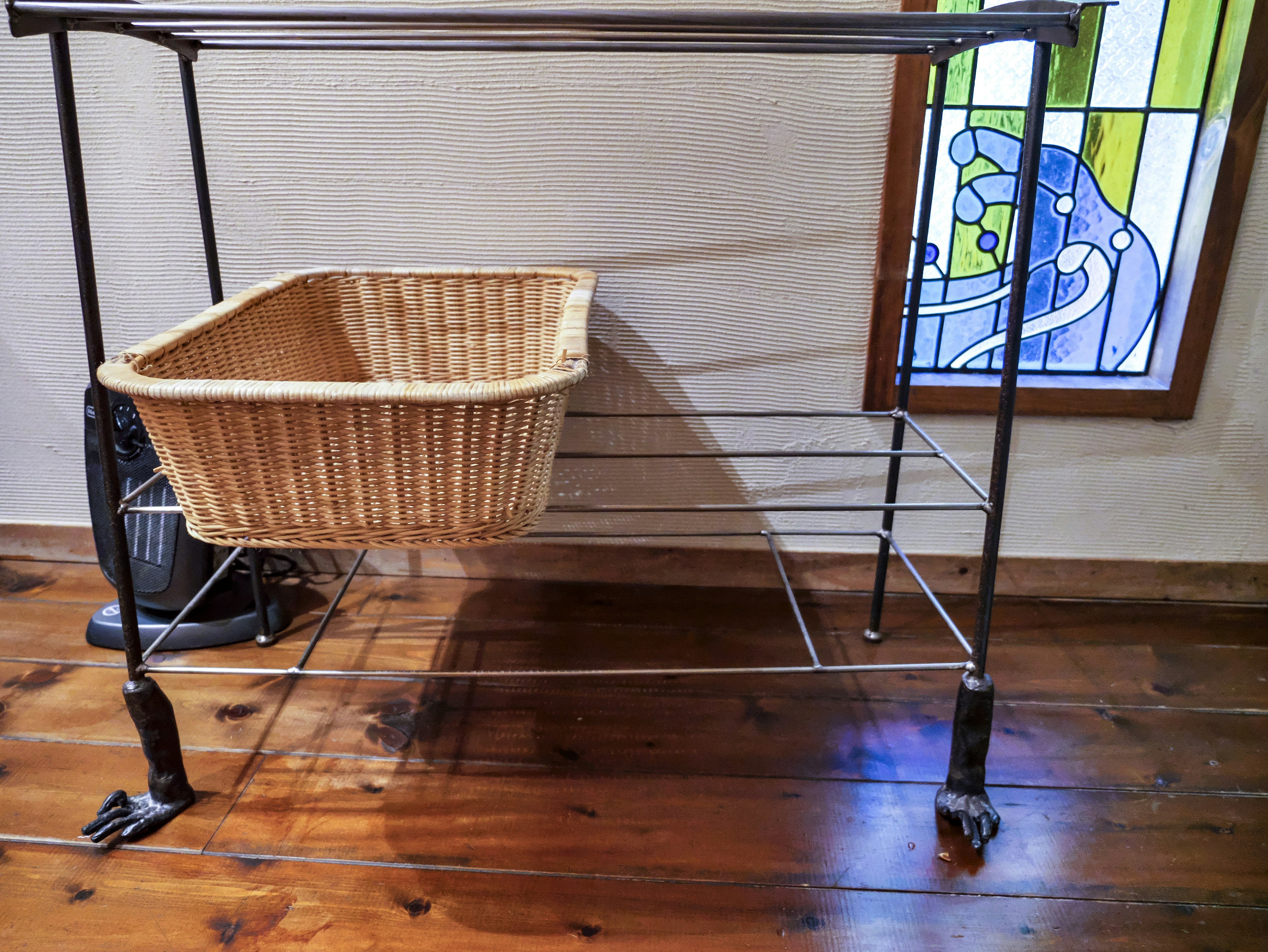 Metal rack with a wicker basket and a stained glass window