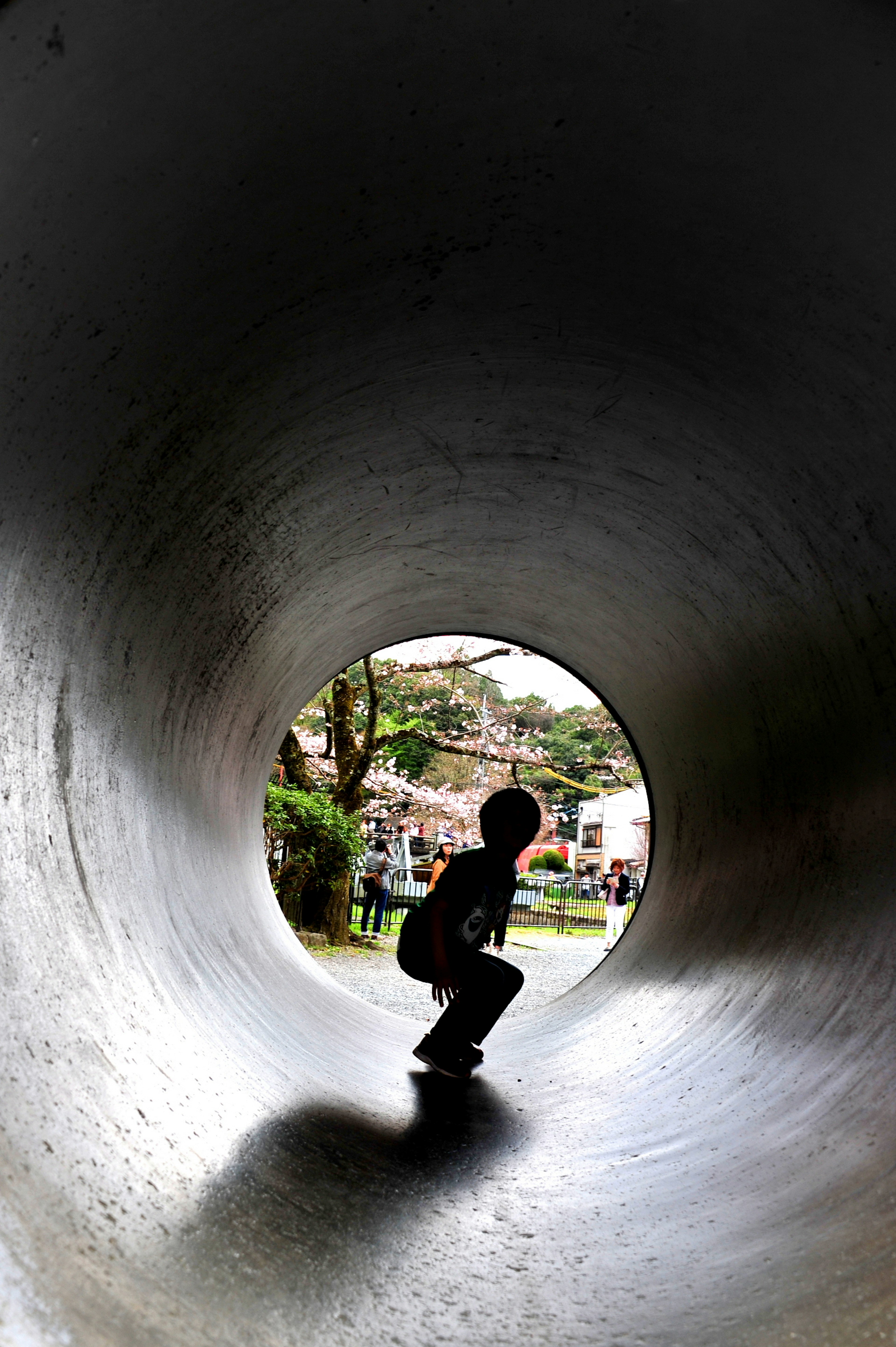 Silhouette di un bambino che fa skateboard all'interno di un tubo