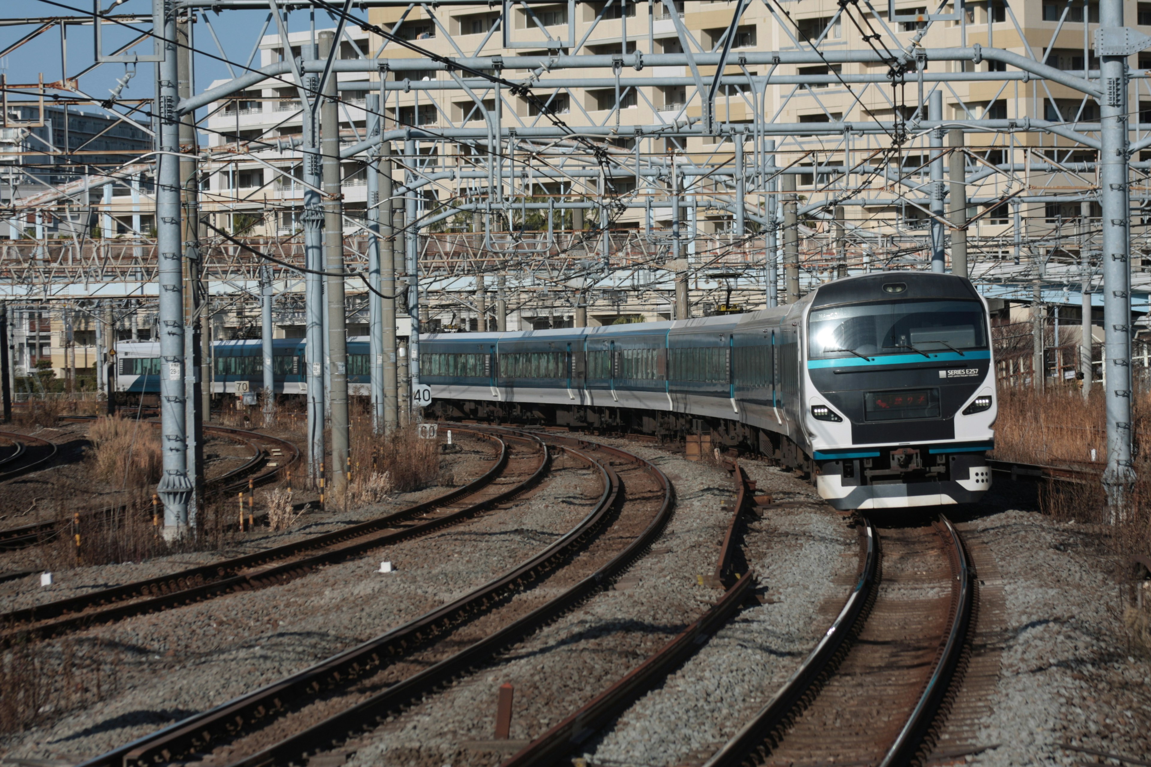 Treno moderno che affronta una curva con linee aeree complesse