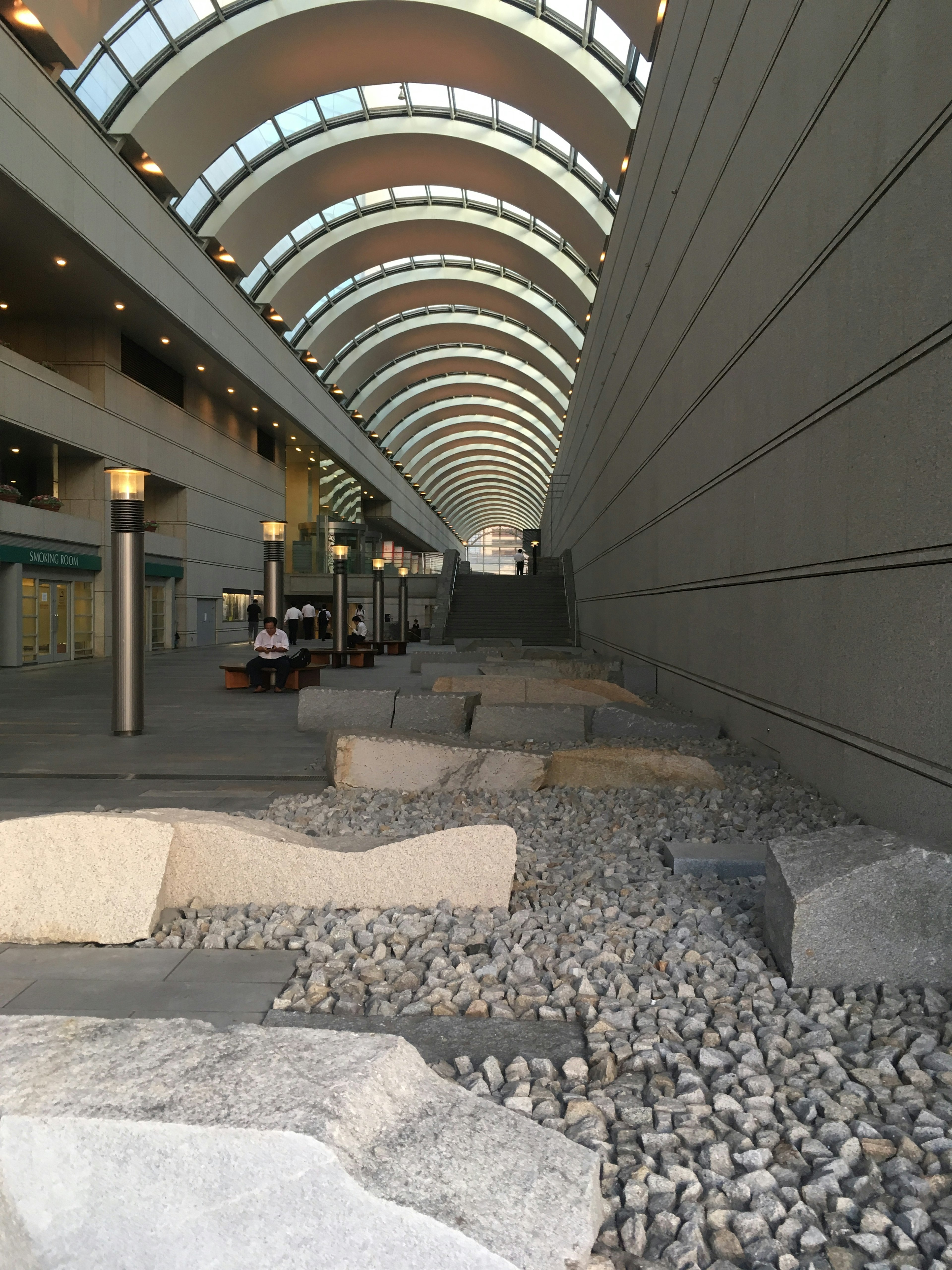 Interior of a modern building featuring a stone garden and smooth arched ceiling