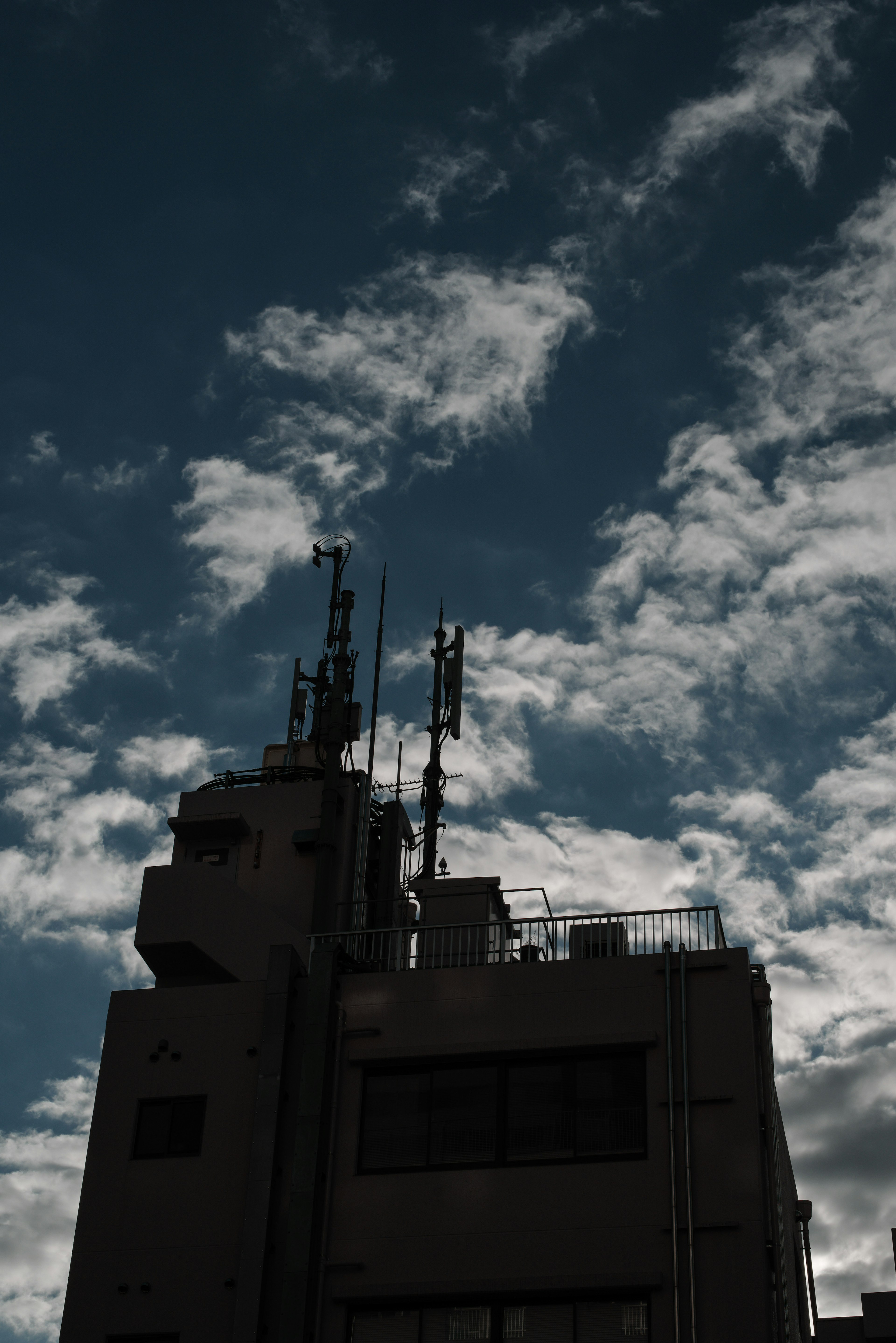 高い建物のシルエットと青い空に浮かぶ雲