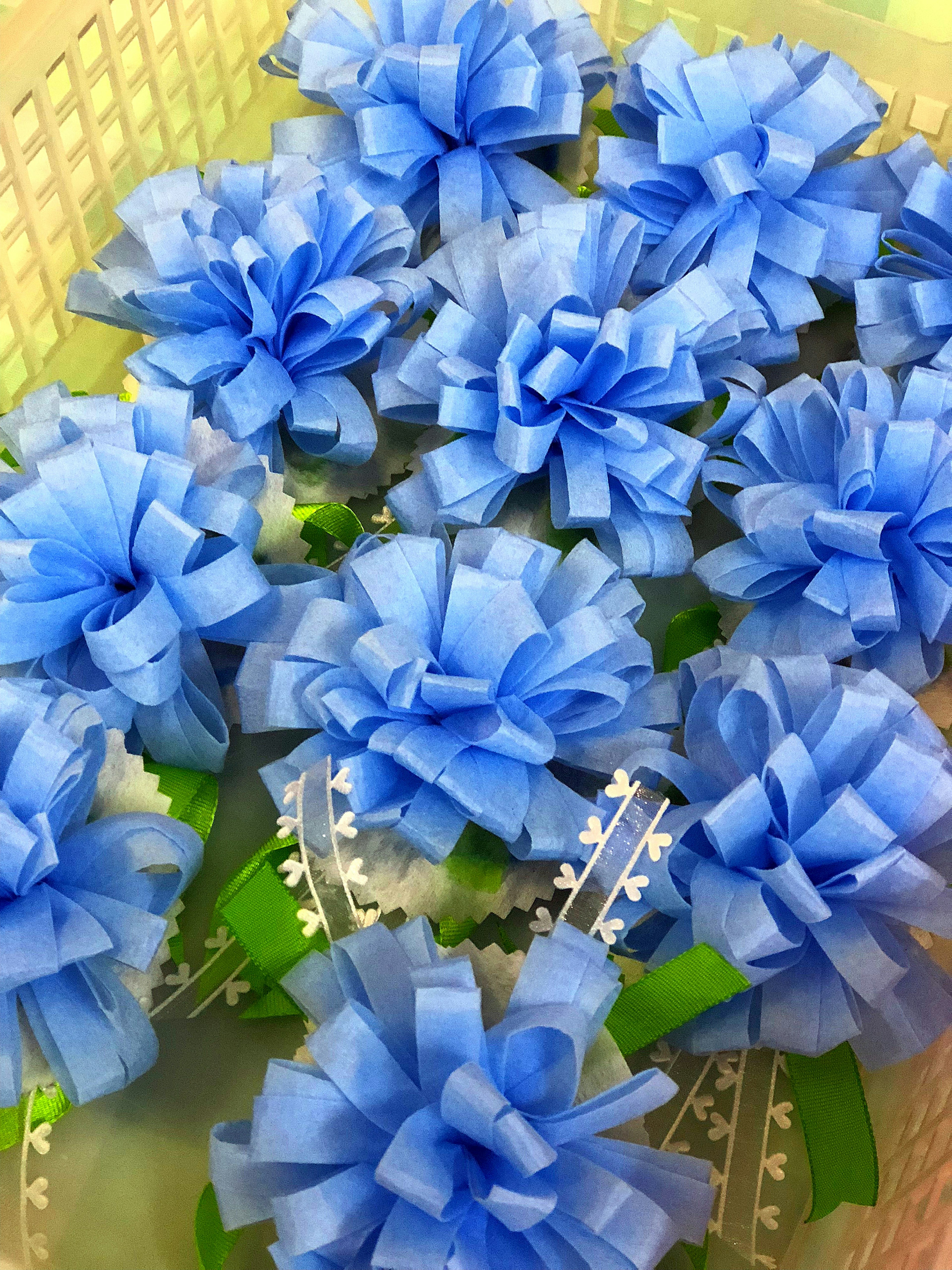 Una colección de flores de cinta azul dispuestas en una cesta