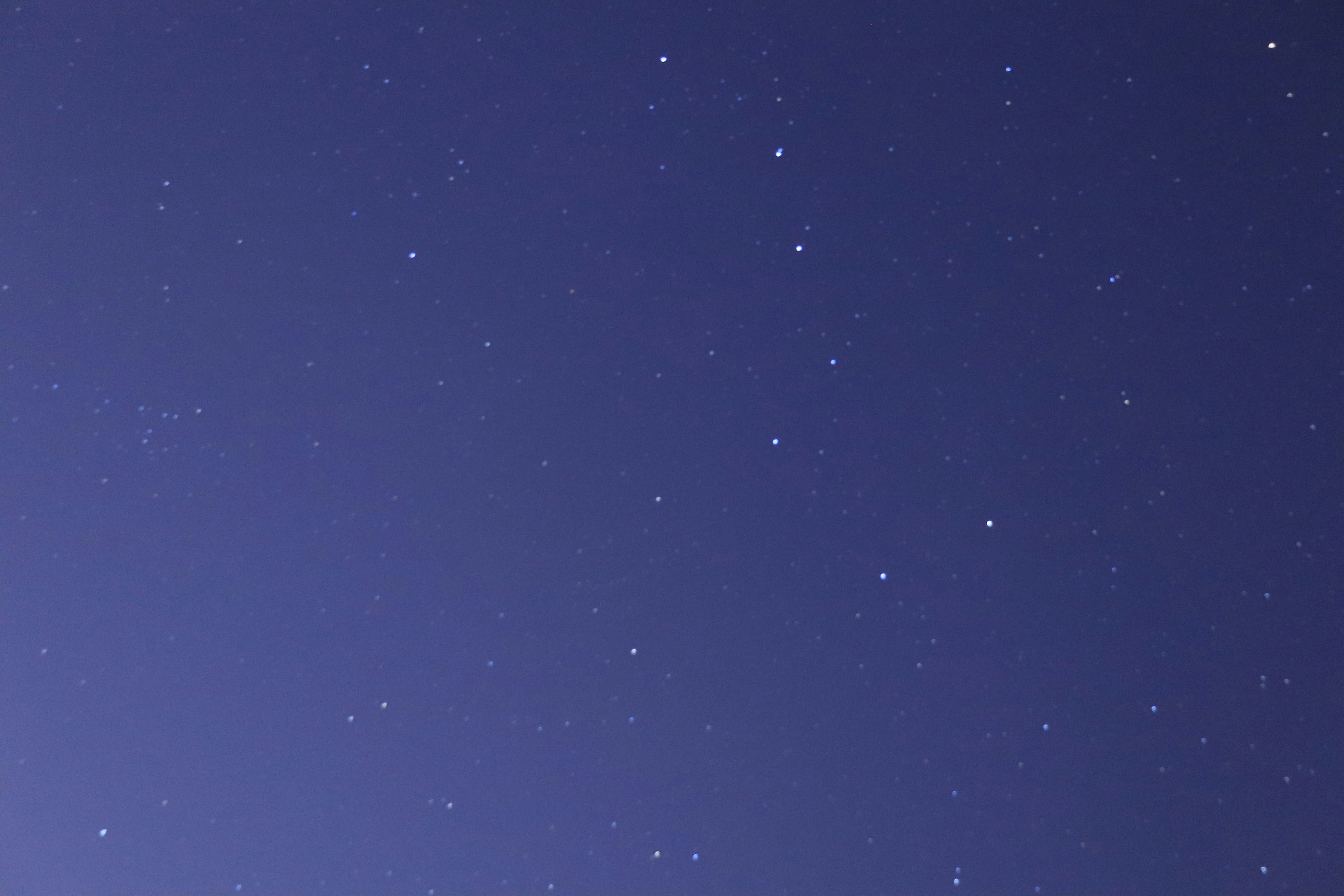 Langit malam dengan bintang bersinar di latar belakang biru tua