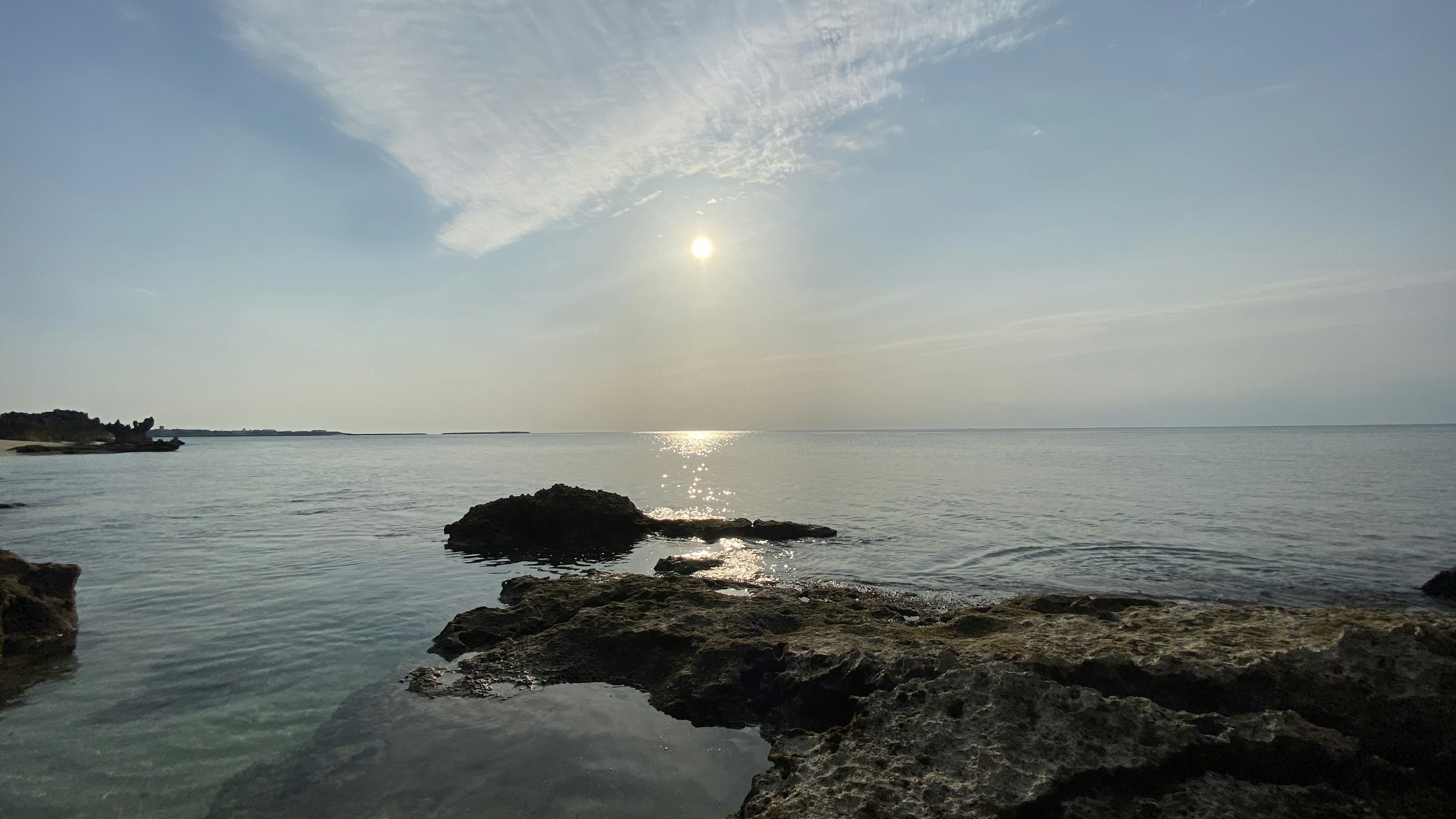 Serene seascape with rocks sunlight reflecting on water