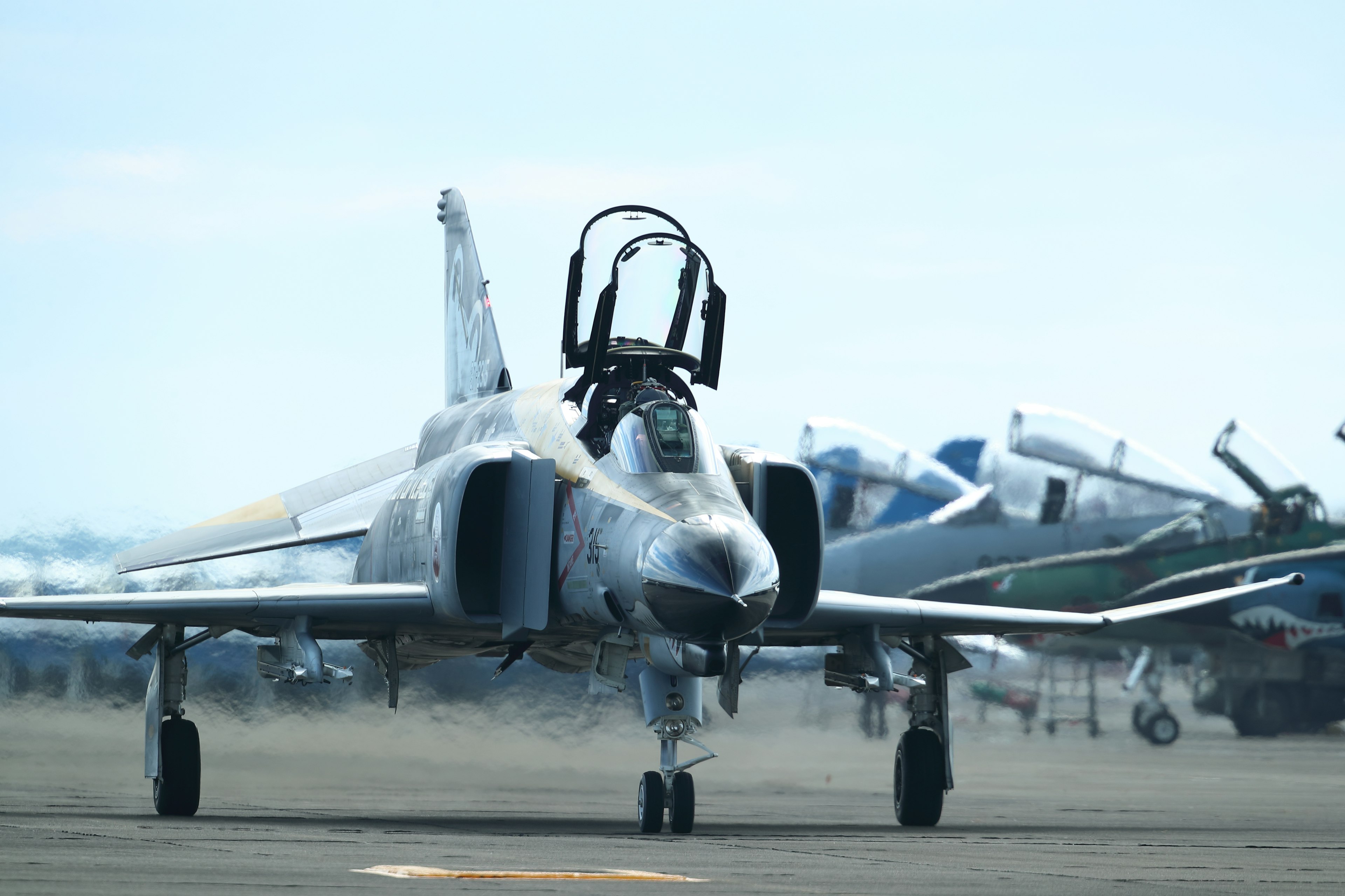 Un caza en la pista con varios aviones al fondo