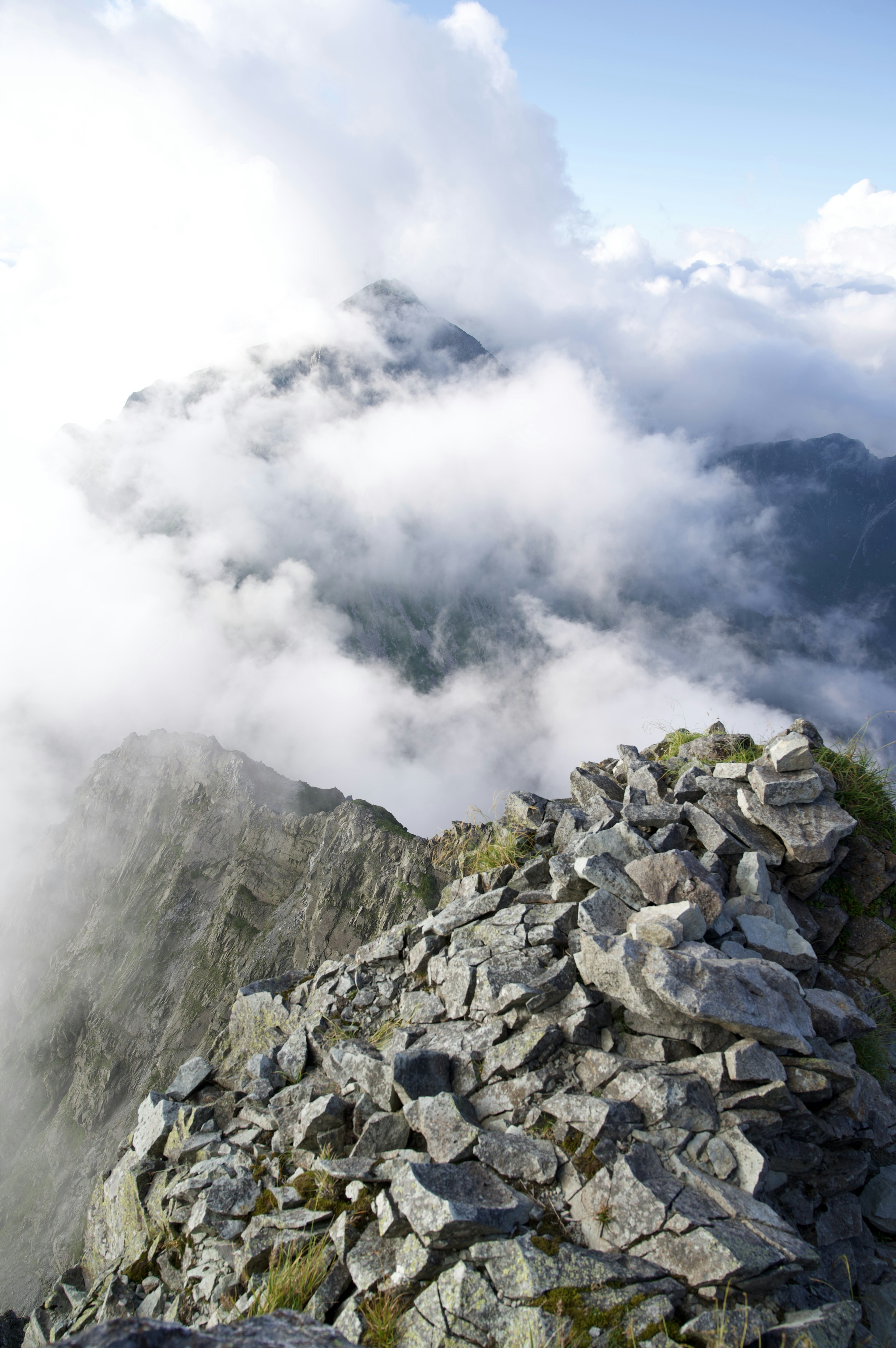 Cima montañosa rocosa con nubes de fondo