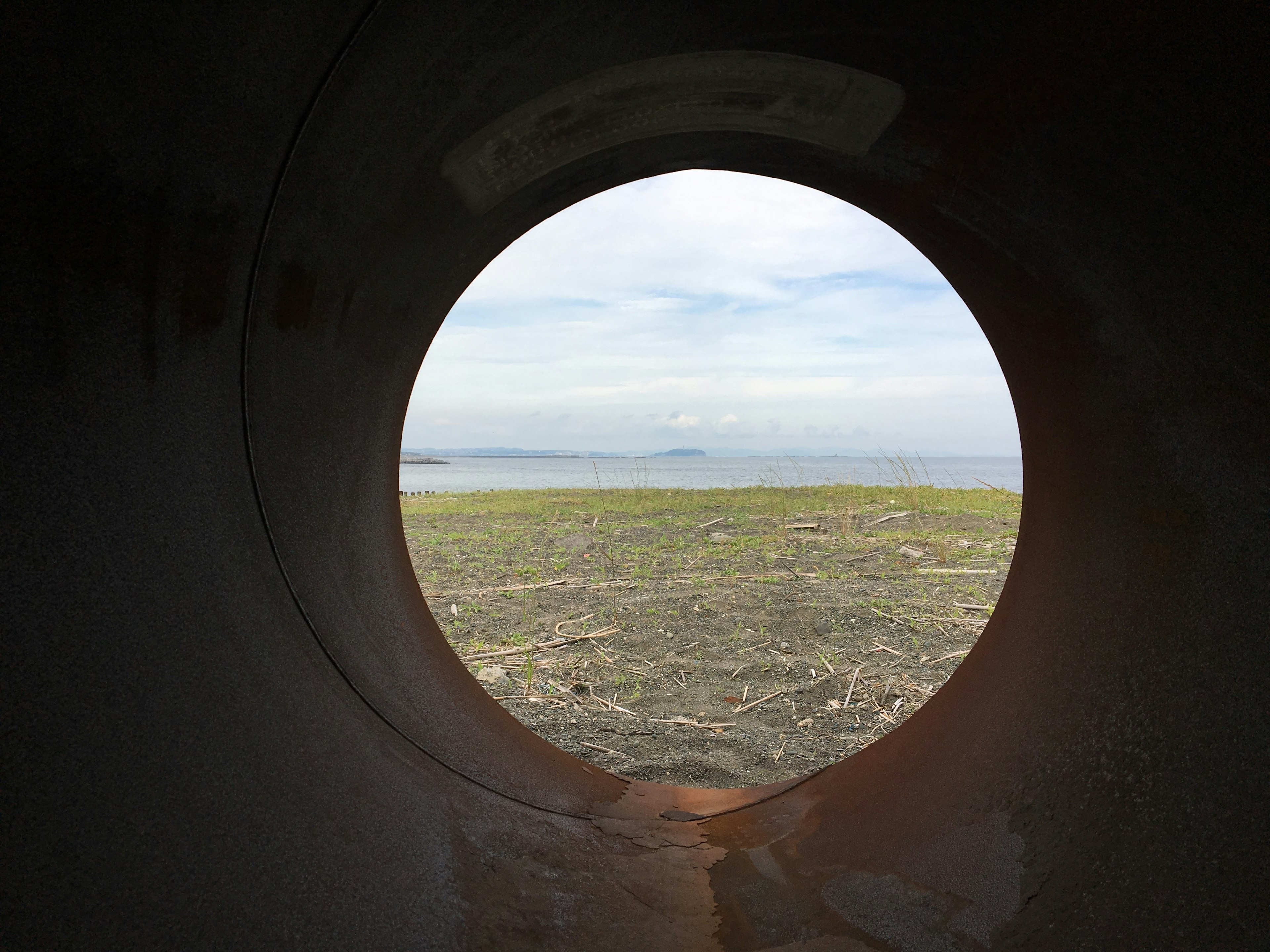 Vue de la mer et du ciel à travers un tunnel circulaire