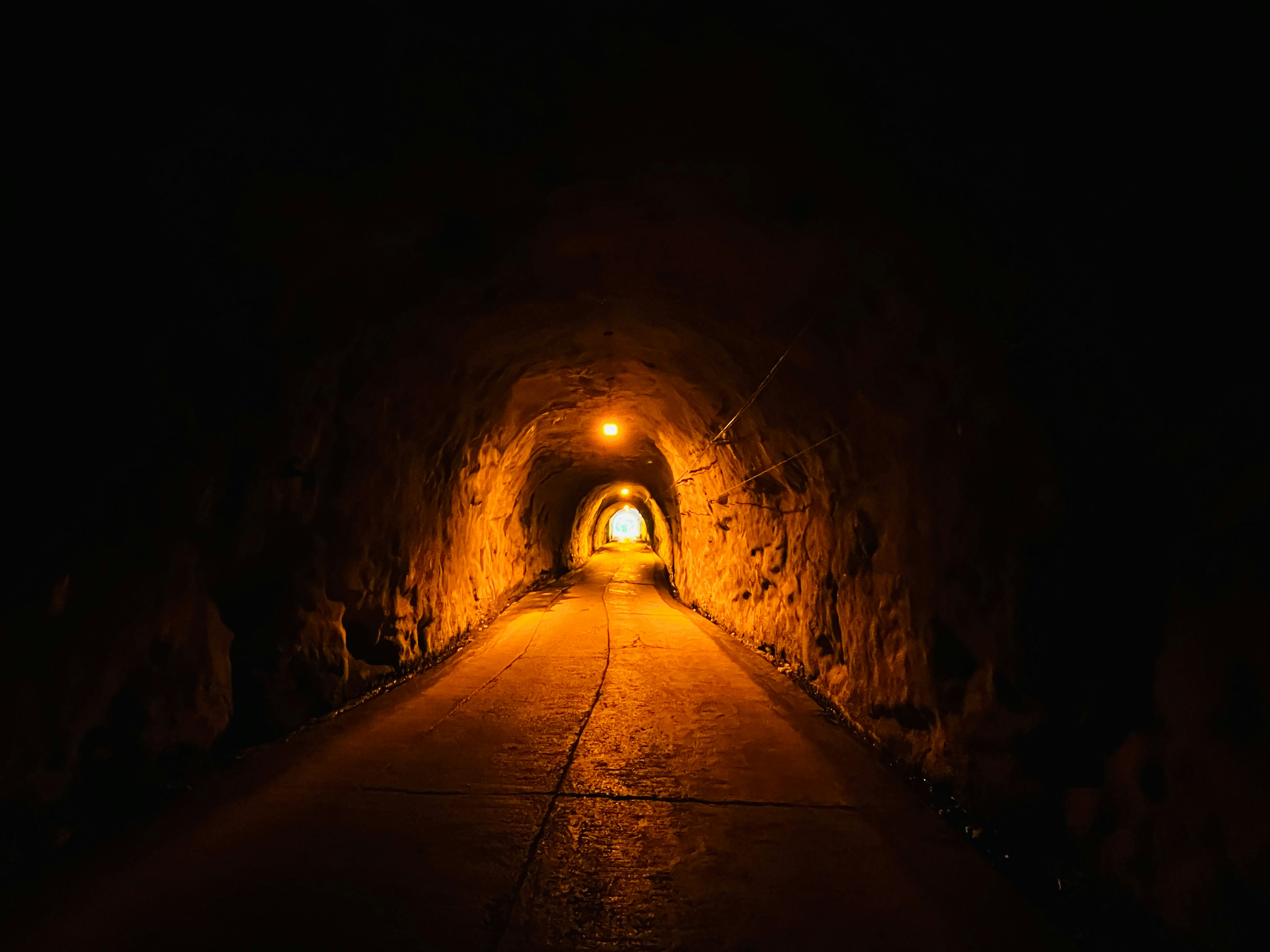 Un túnel oscuro con luz naranja brillante al final