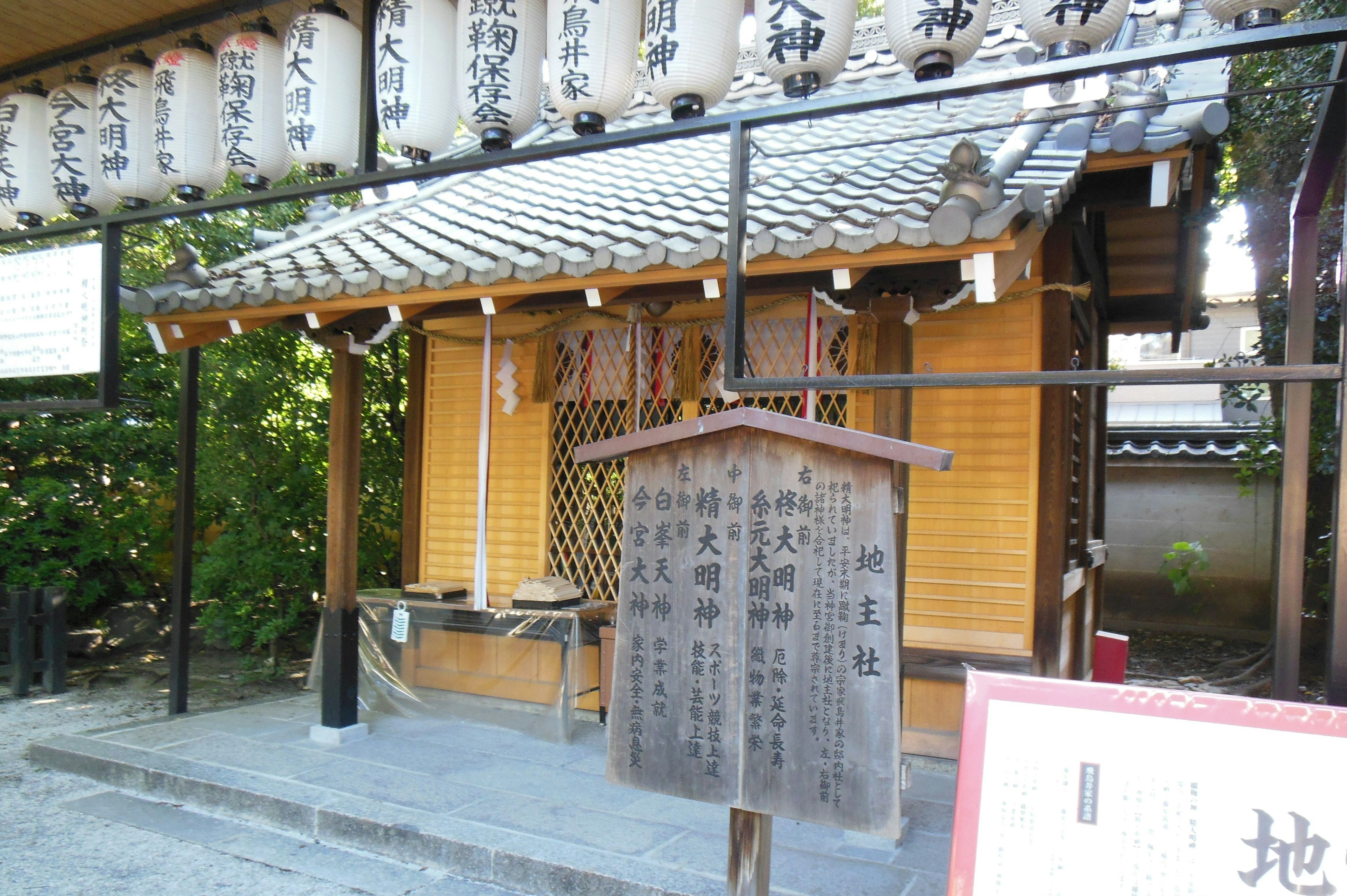 Small wooden shrine building with hanging lanterns