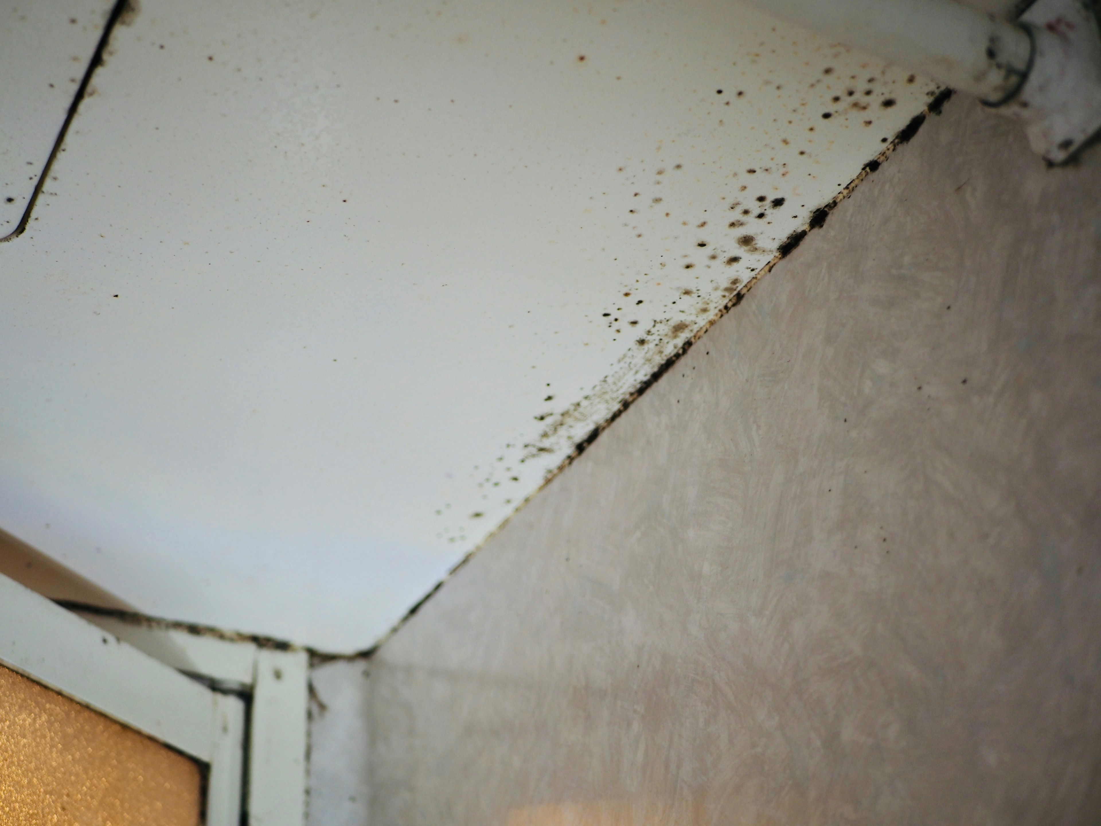 Image montrant un coin rouillé d'un mur blanc et d'une surface métallique