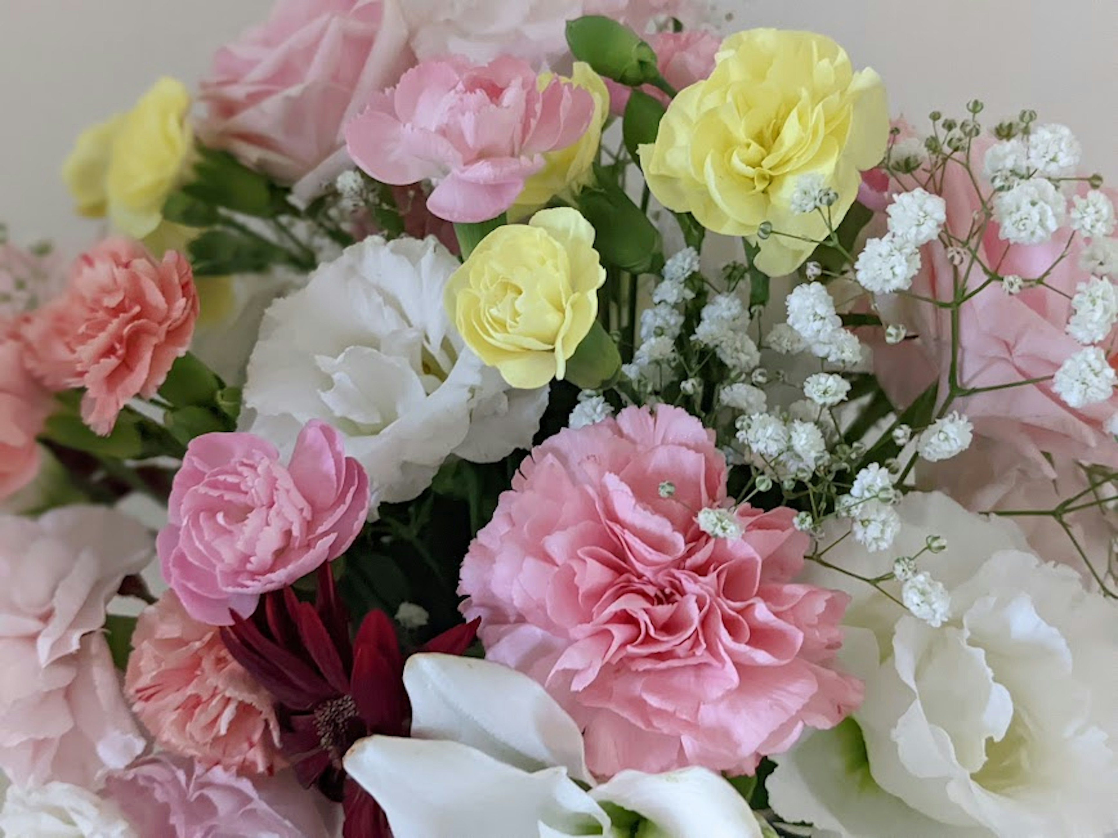 Un bouquet coloré avec des roses roses et jaunes ainsi que des fleurs blanches