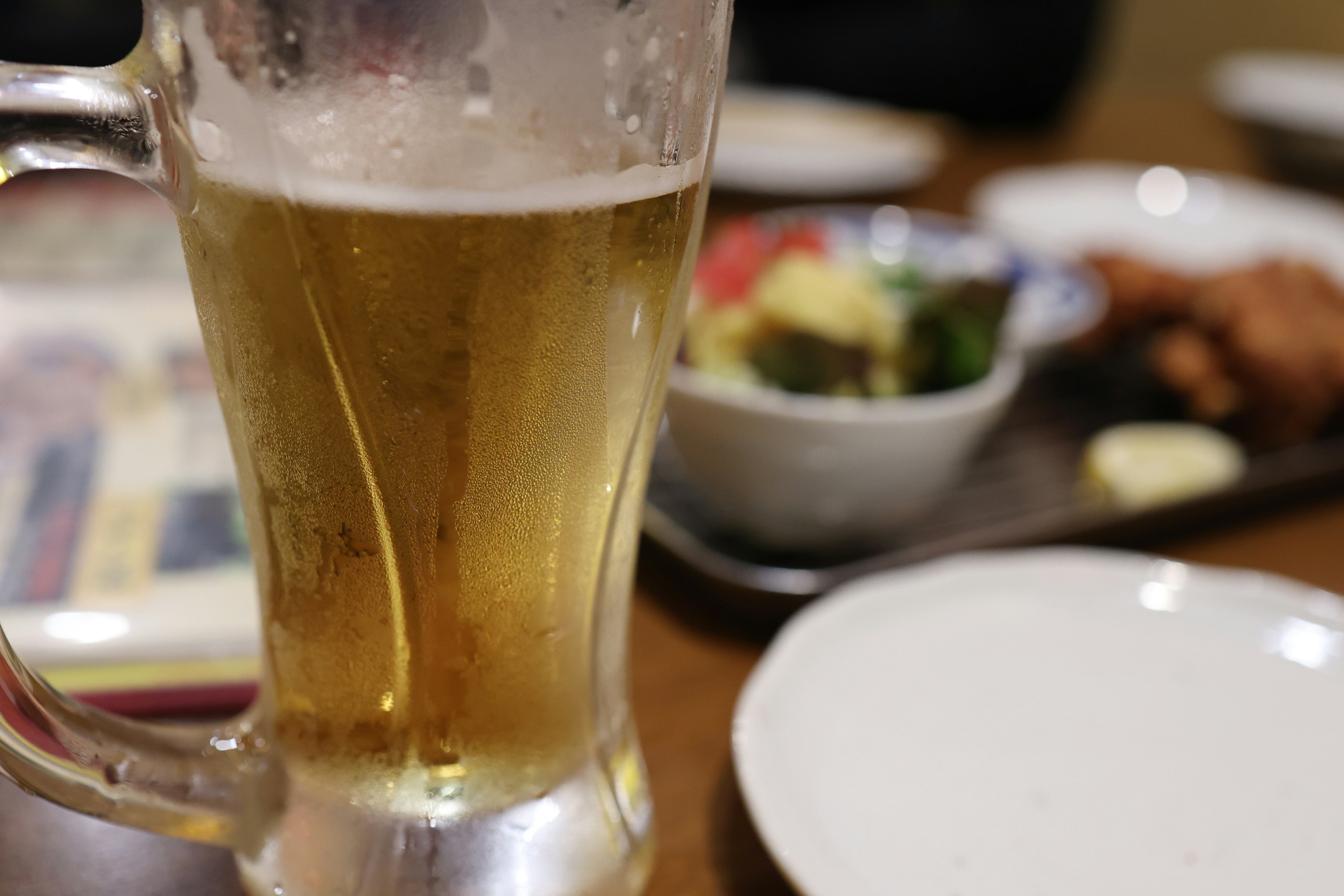 Gros plan d'une chope de bière avec de la nourriture sur une table