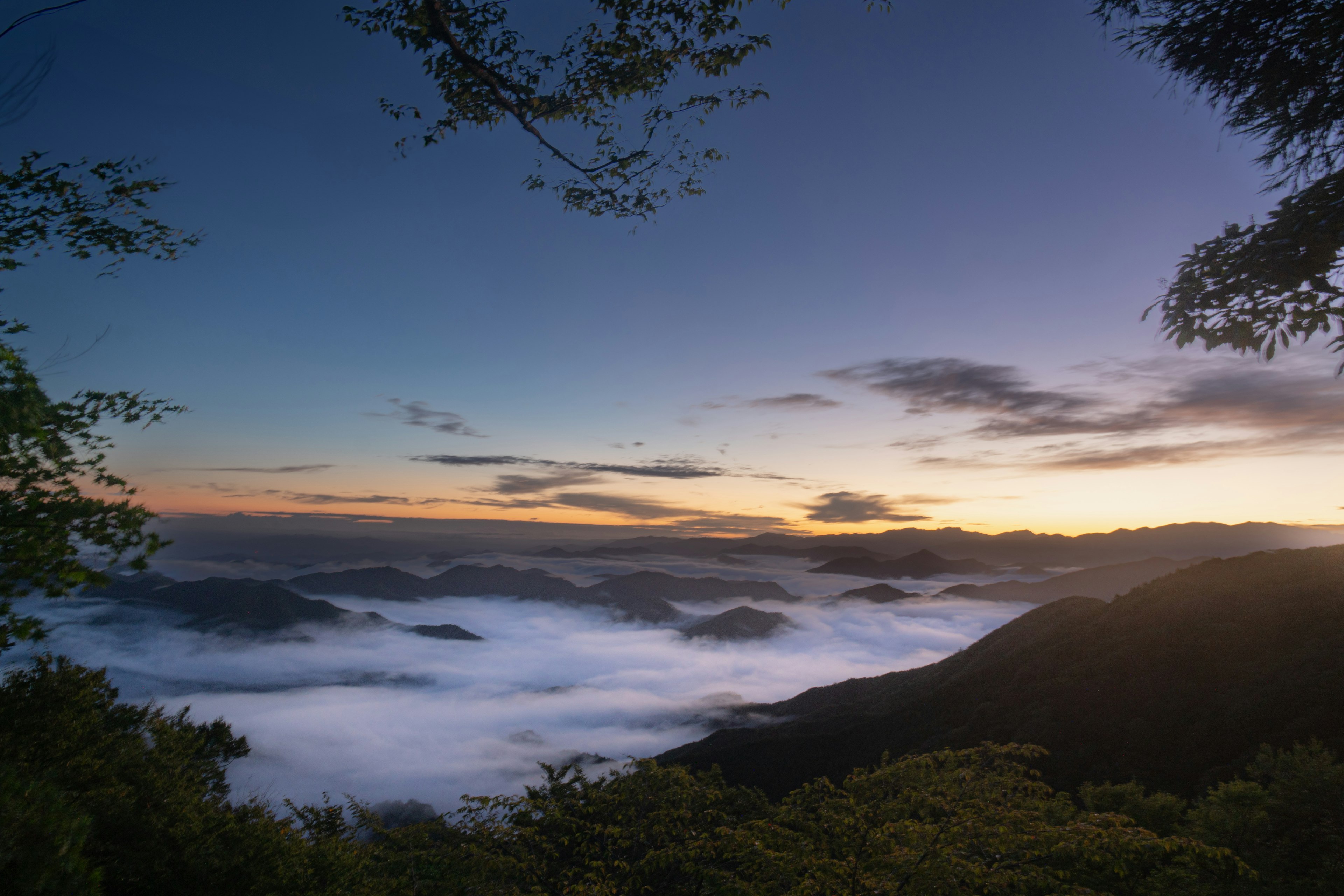 안개에 덮인 산과 다채로운 석양 하늘의 경치