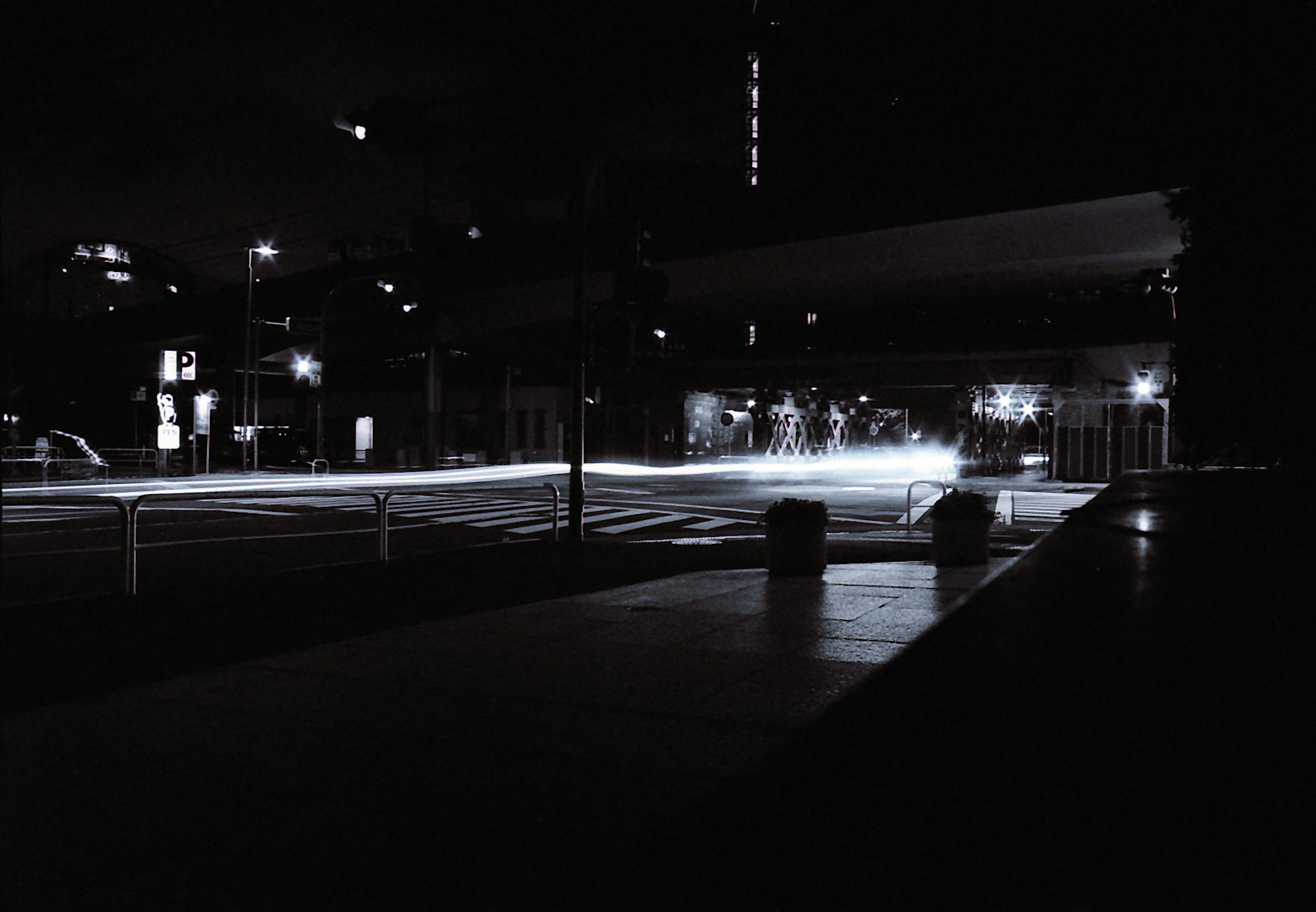 Scène urbaine nocturne montrant des contrastes de lumière et d'ombre