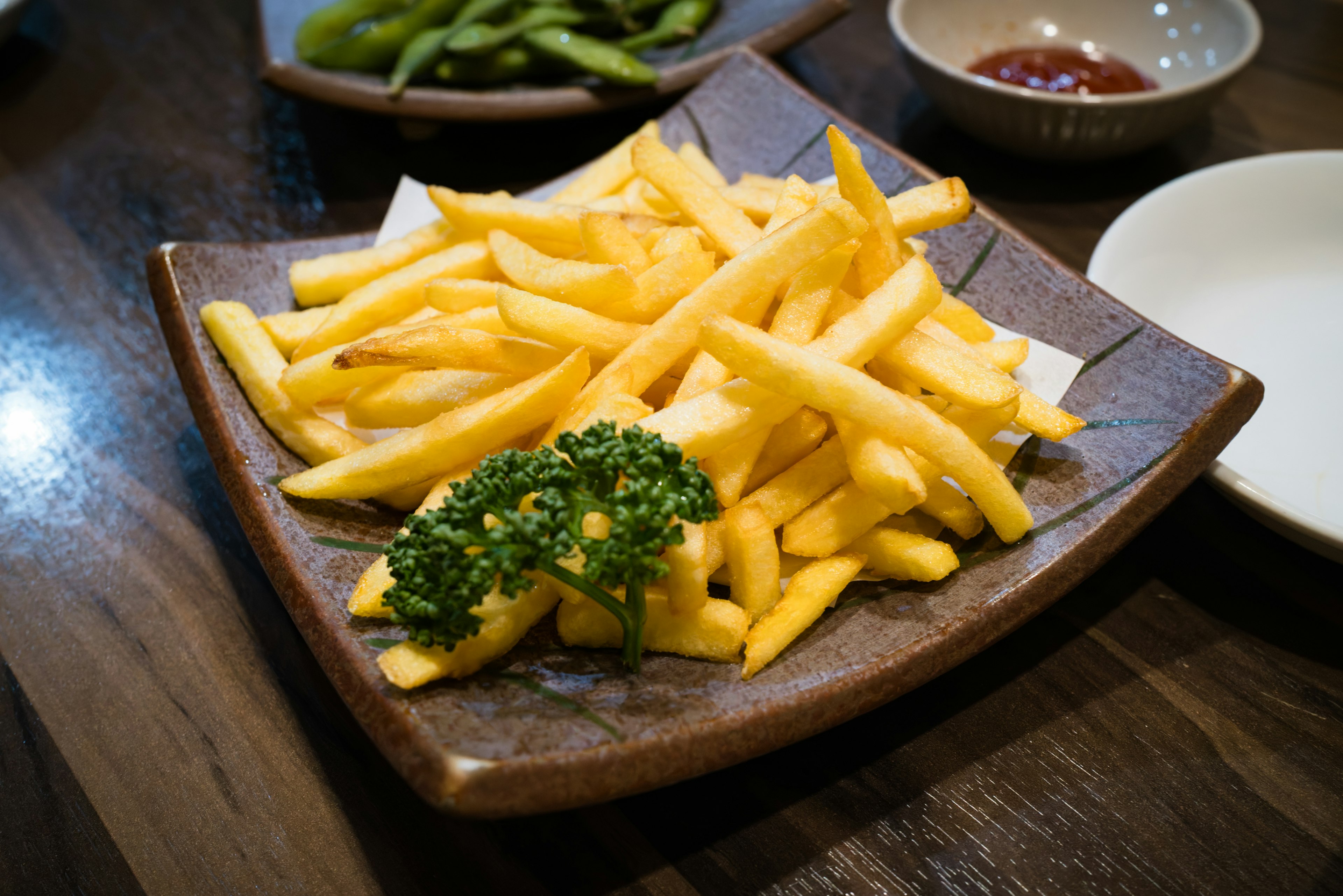 Piatto di patatine fritte dorate guarnite con prezzemolo