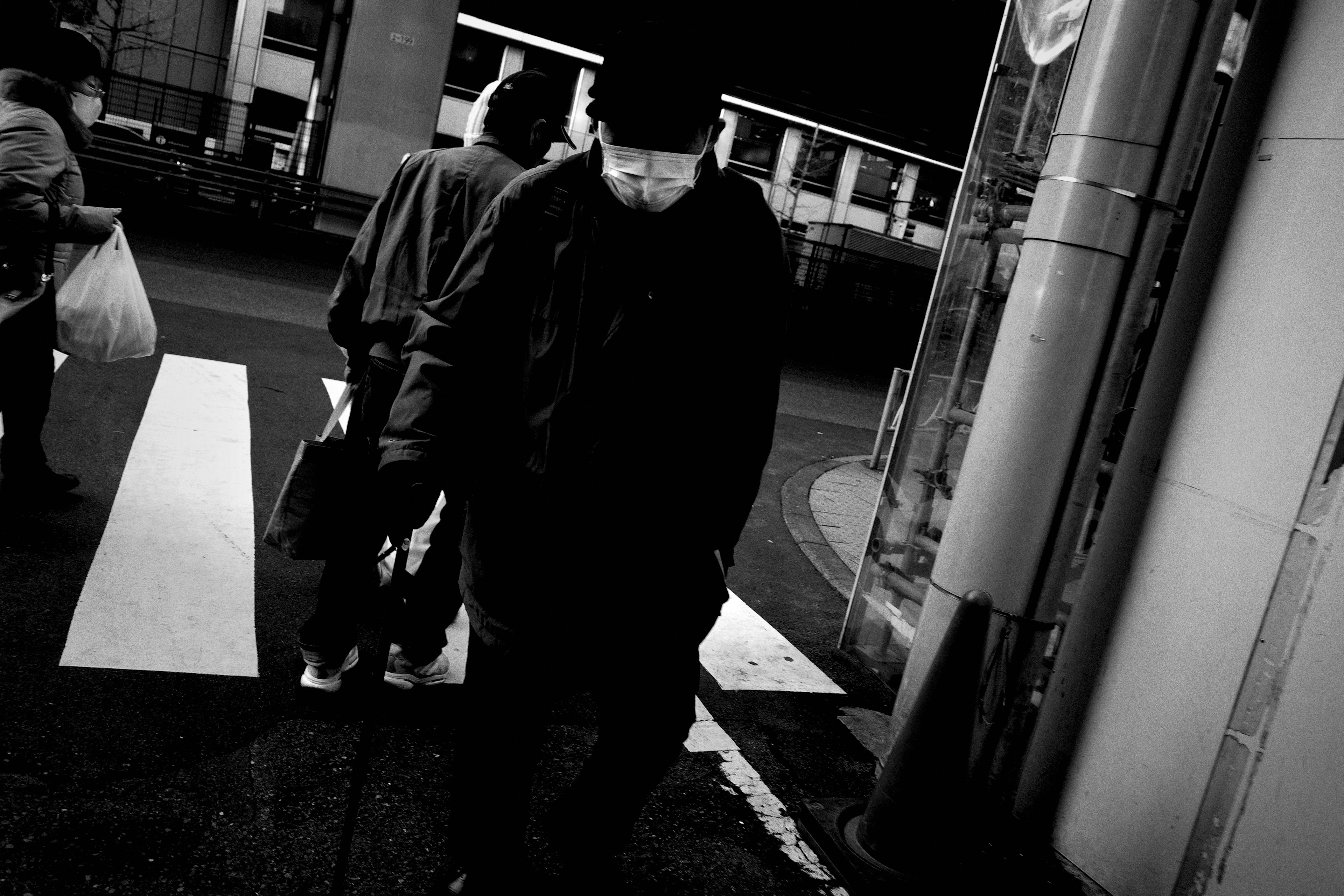 Silhouettes of people crossing the street at night with a dark atmosphere