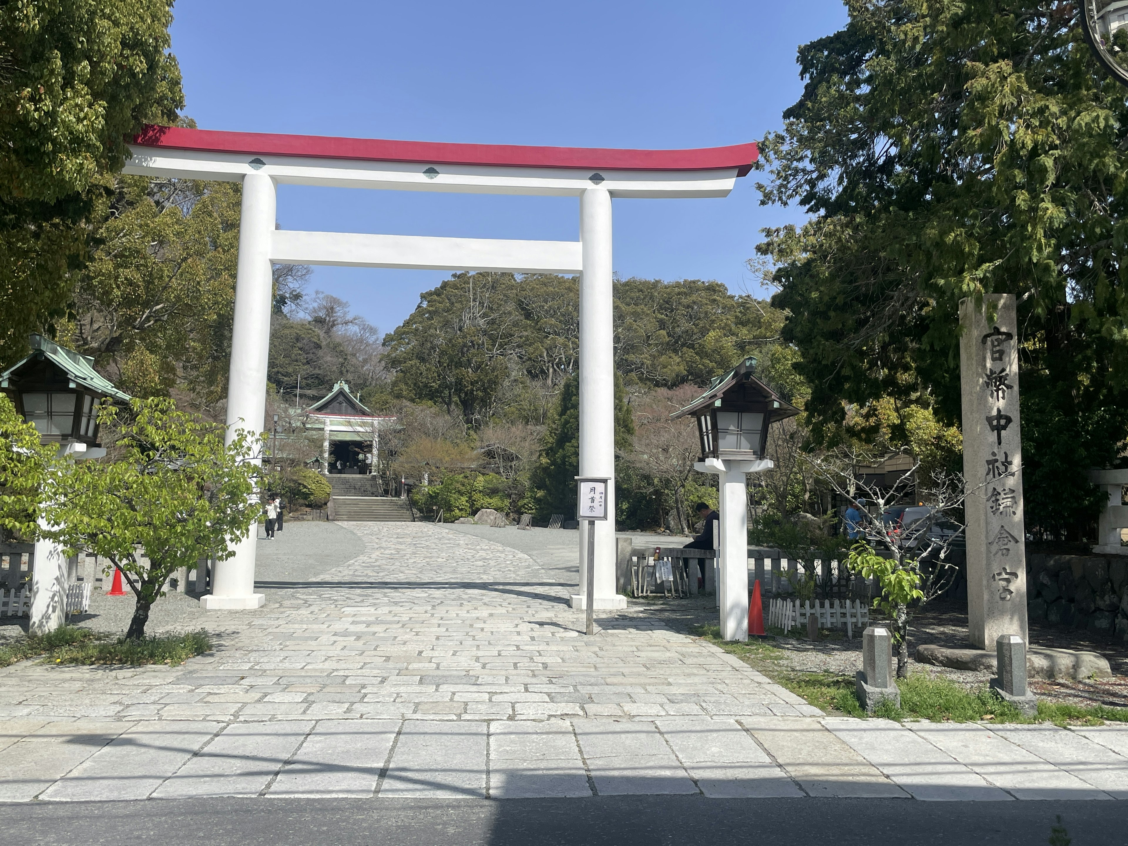 Eingang eines Schreins mit einem roten Torii und Steingefäßen