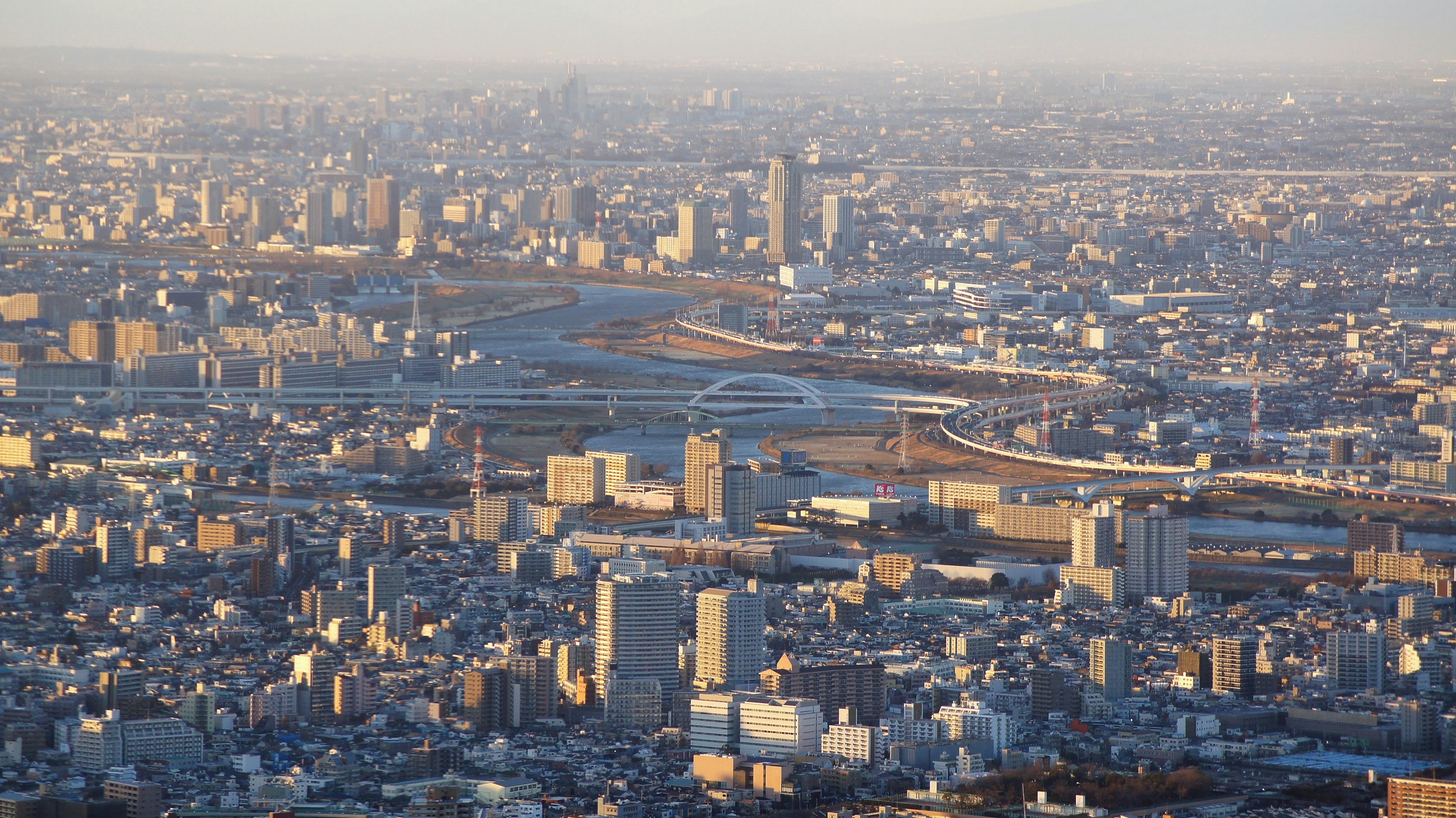 Aerial view of a cityscape with residential buildings and a river at sunset