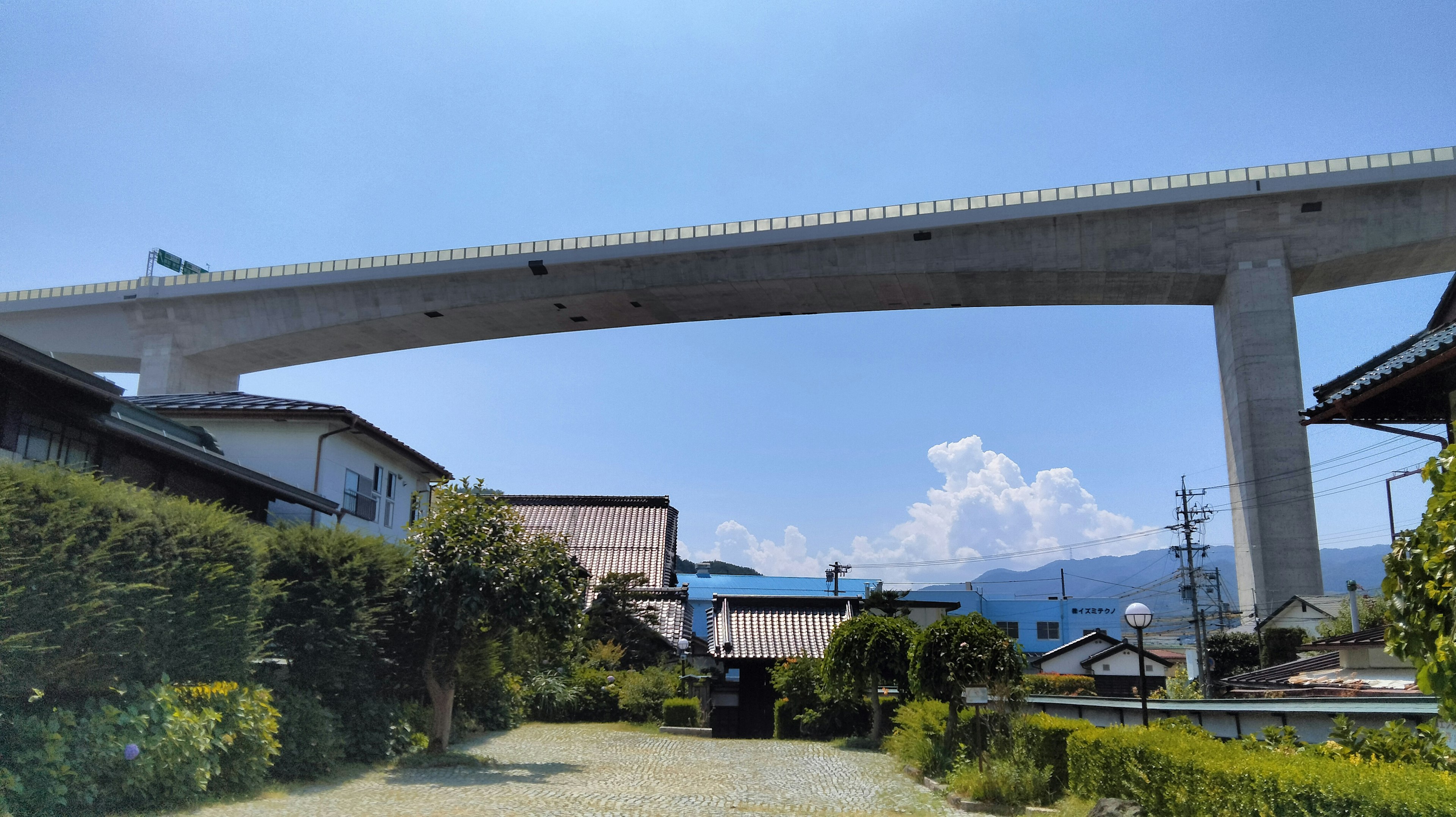 青空の下にある高架道路と周囲の住宅