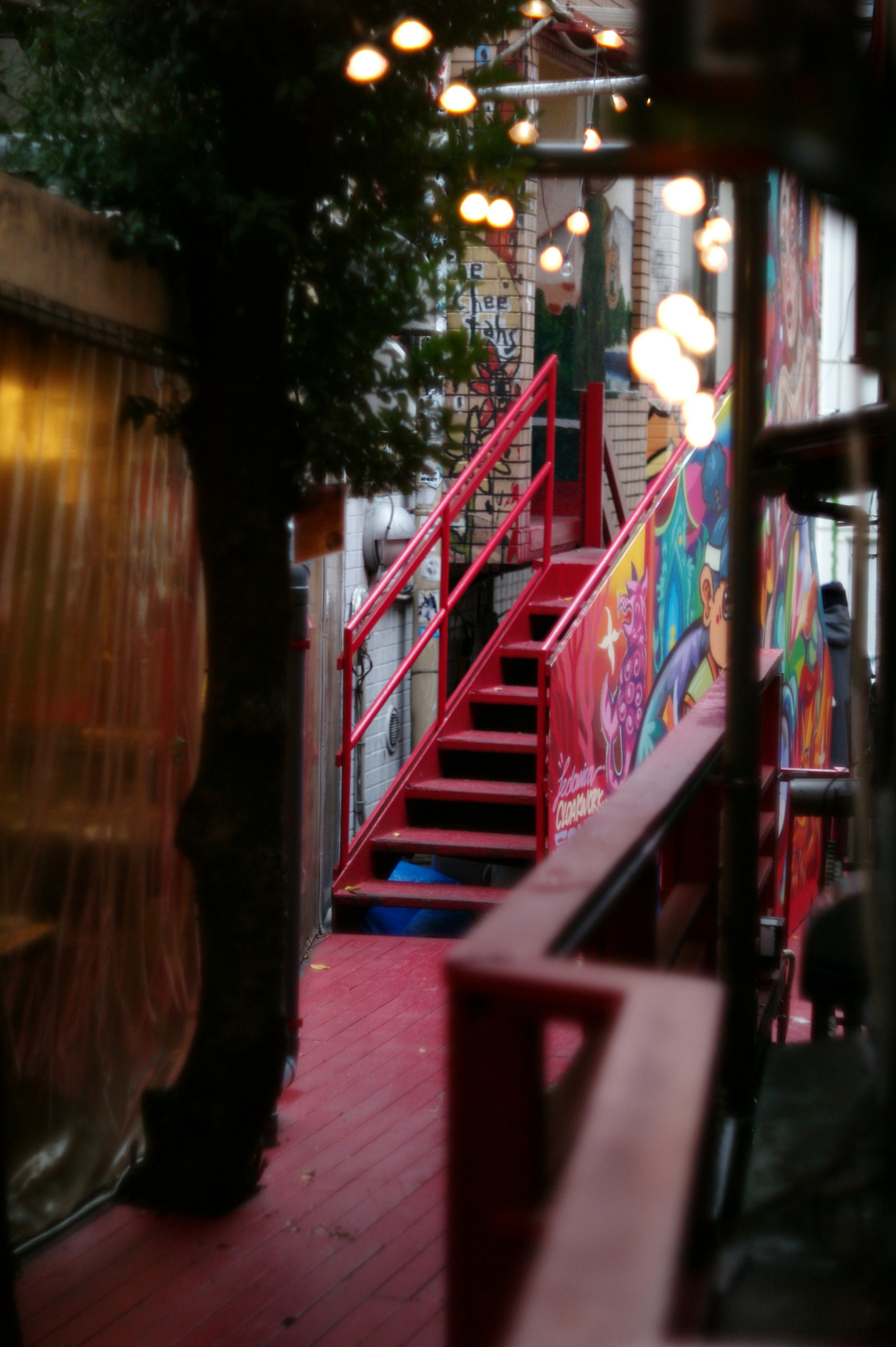 Camino con una escalera roja y un mural colorido