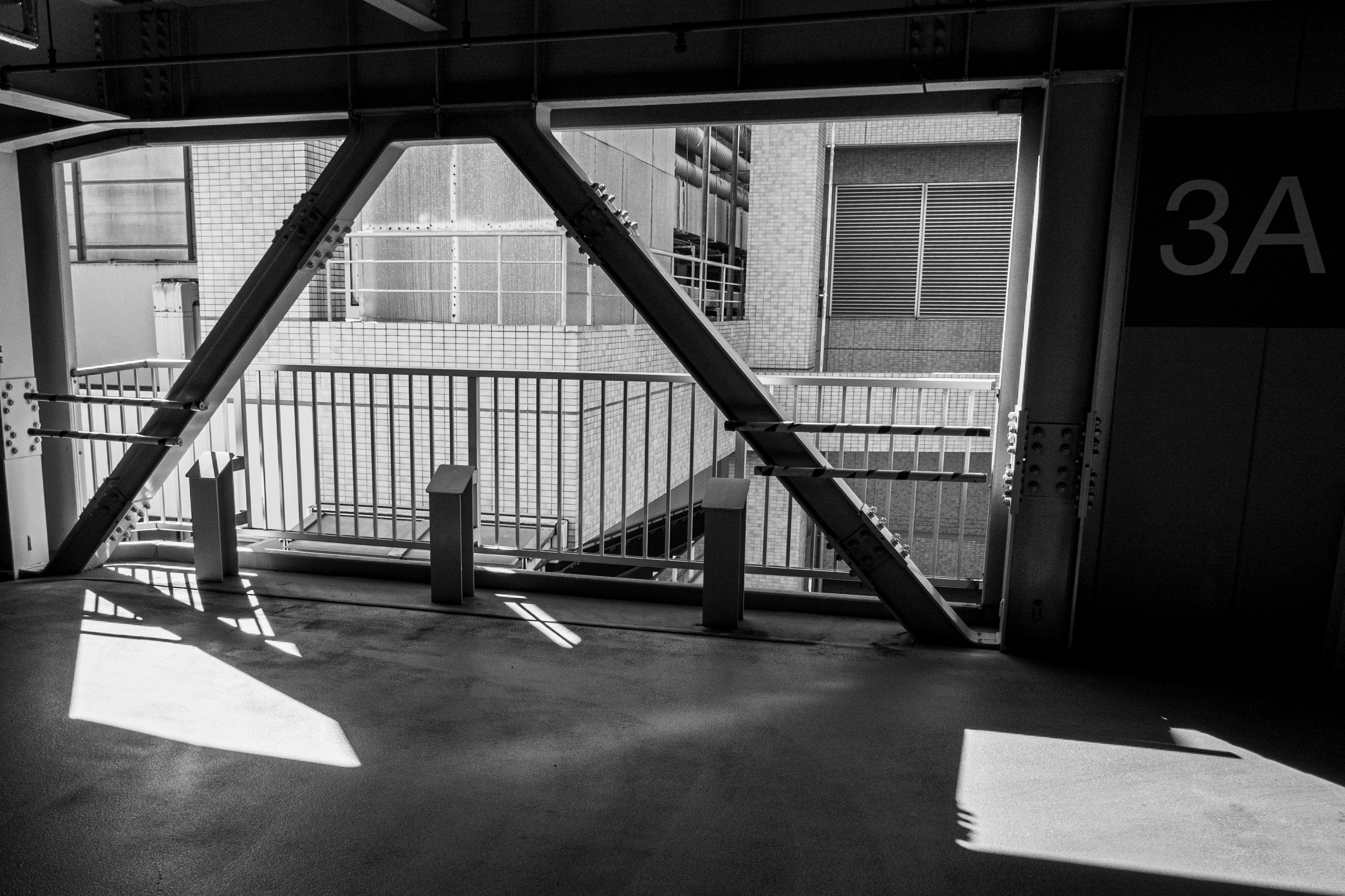 Estructura de estacionamiento en blanco y negro con gran ventana y armazón metálico