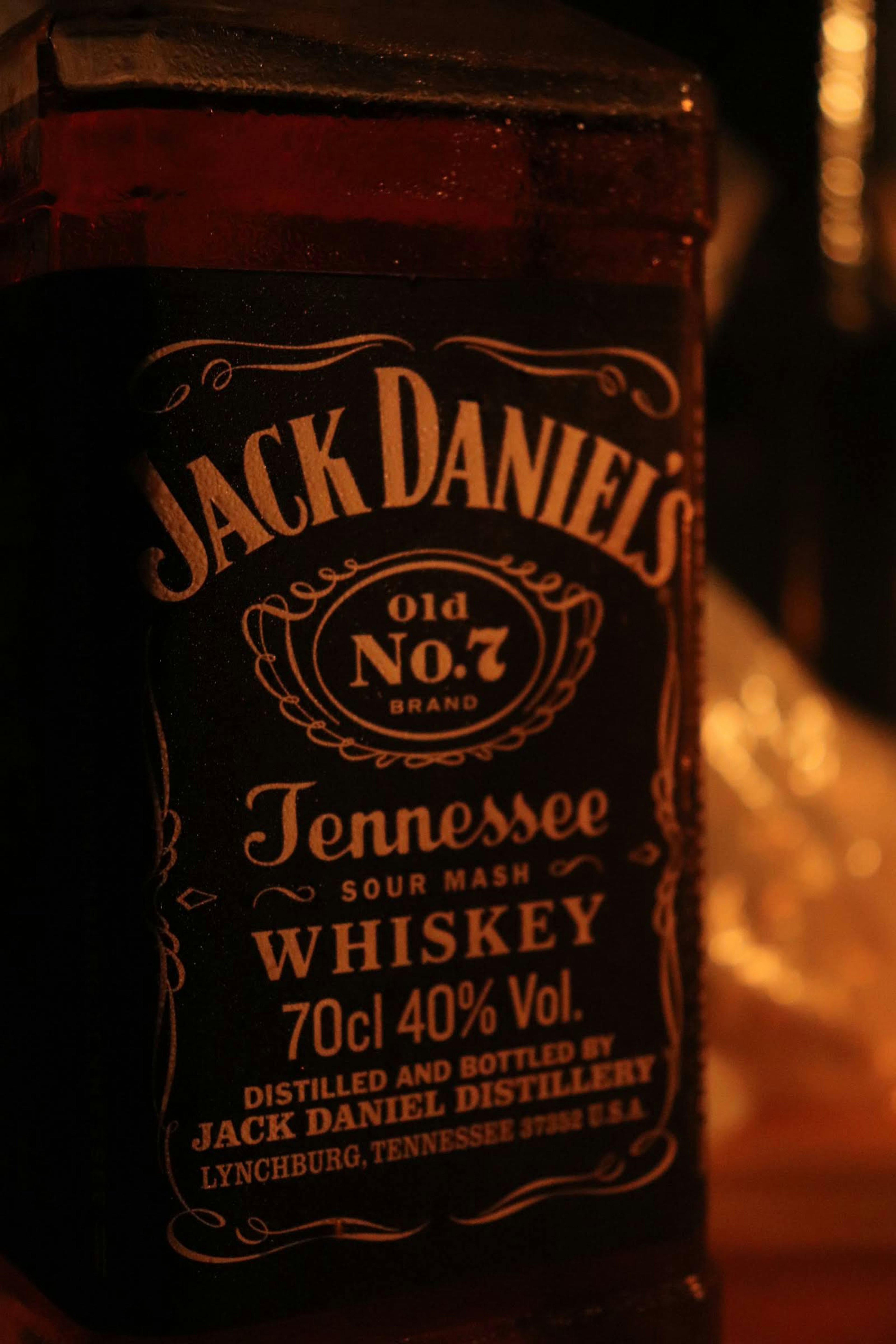 Jack Daniel's whiskey bottle illuminated against a dark background