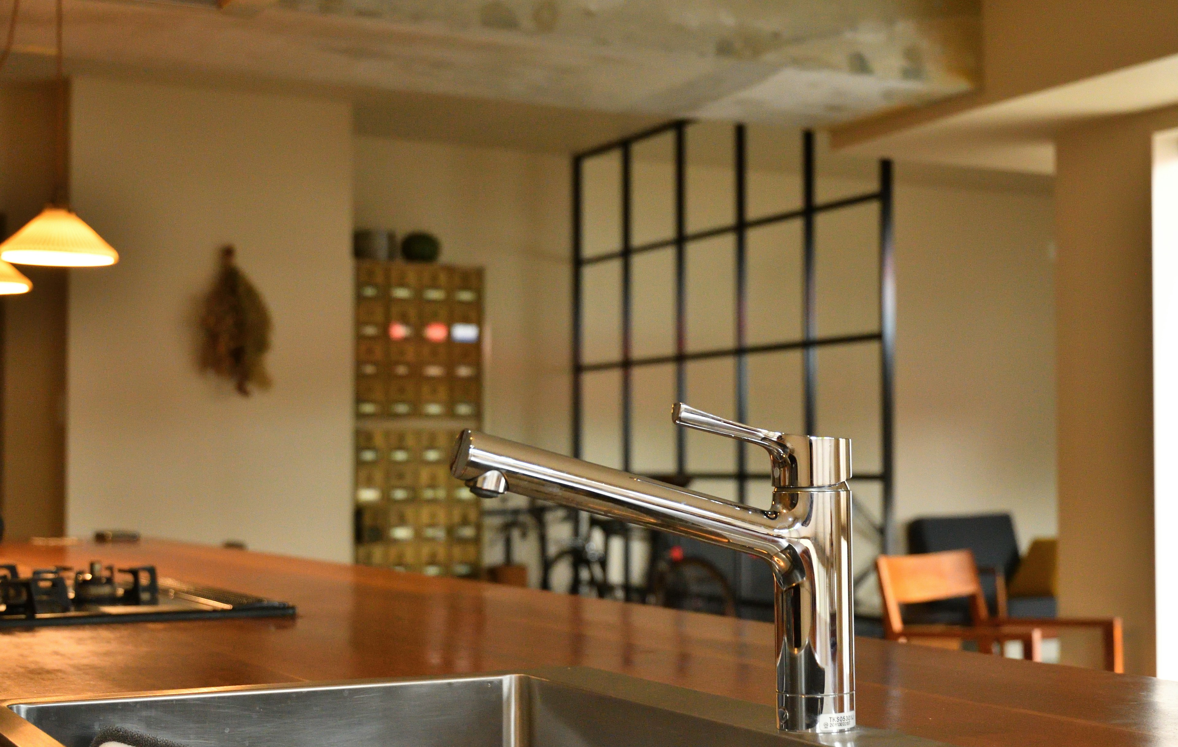 Close-up of a modern kitchen sink and faucet featuring stylish interior elements