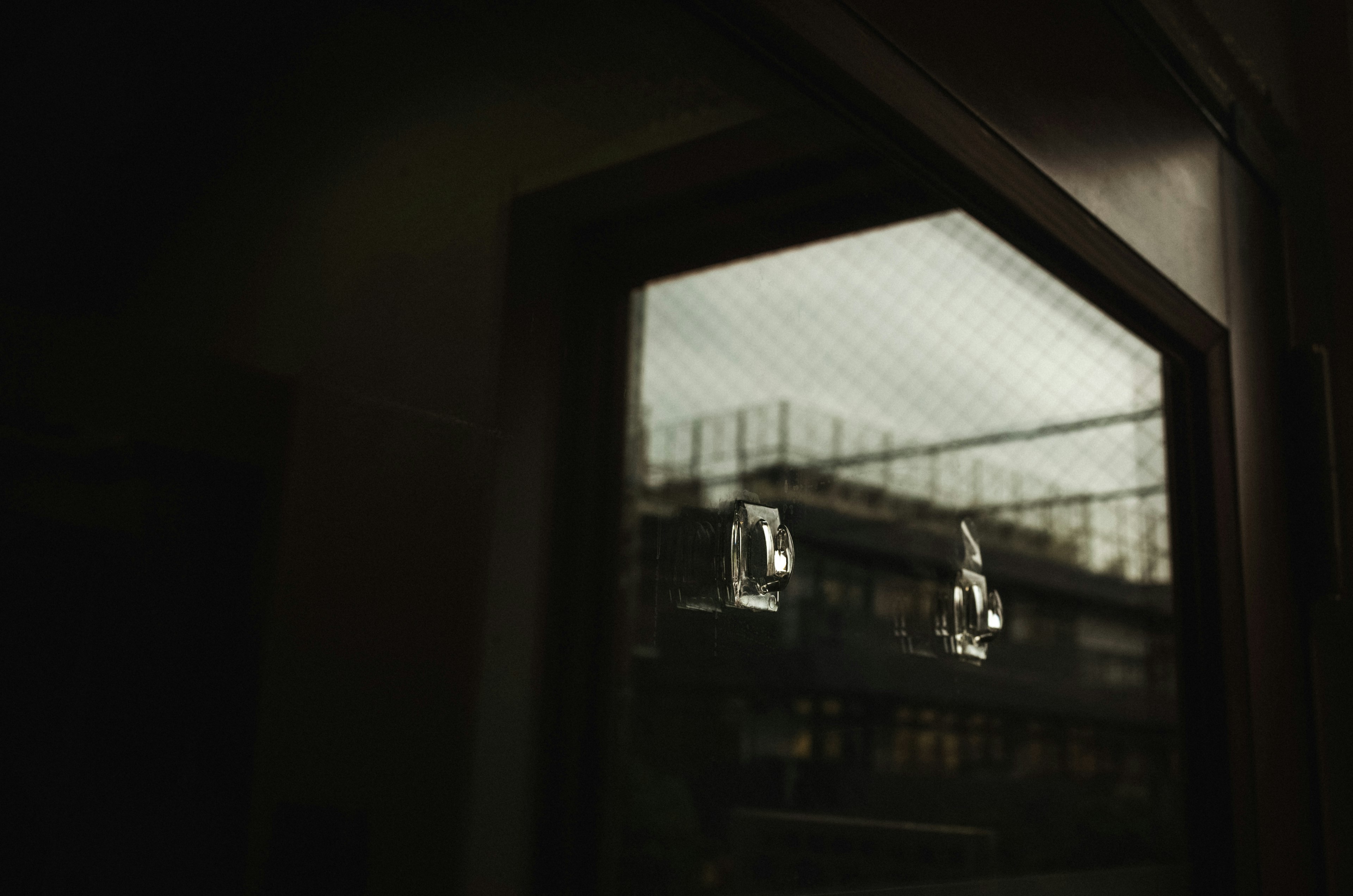 View through a window showing a building and dark interior