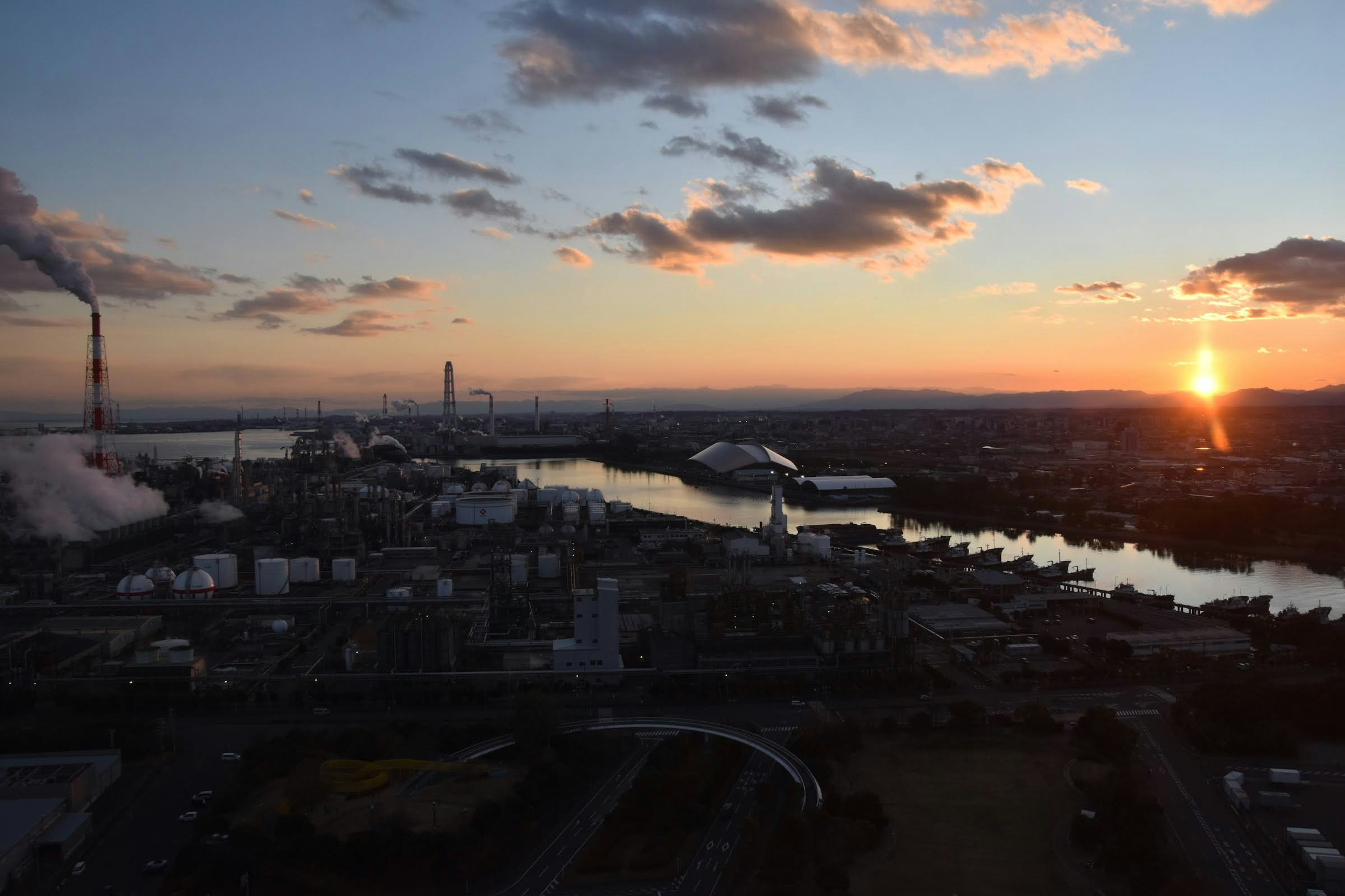 夕日が沈む街の景色 工場と川の風景