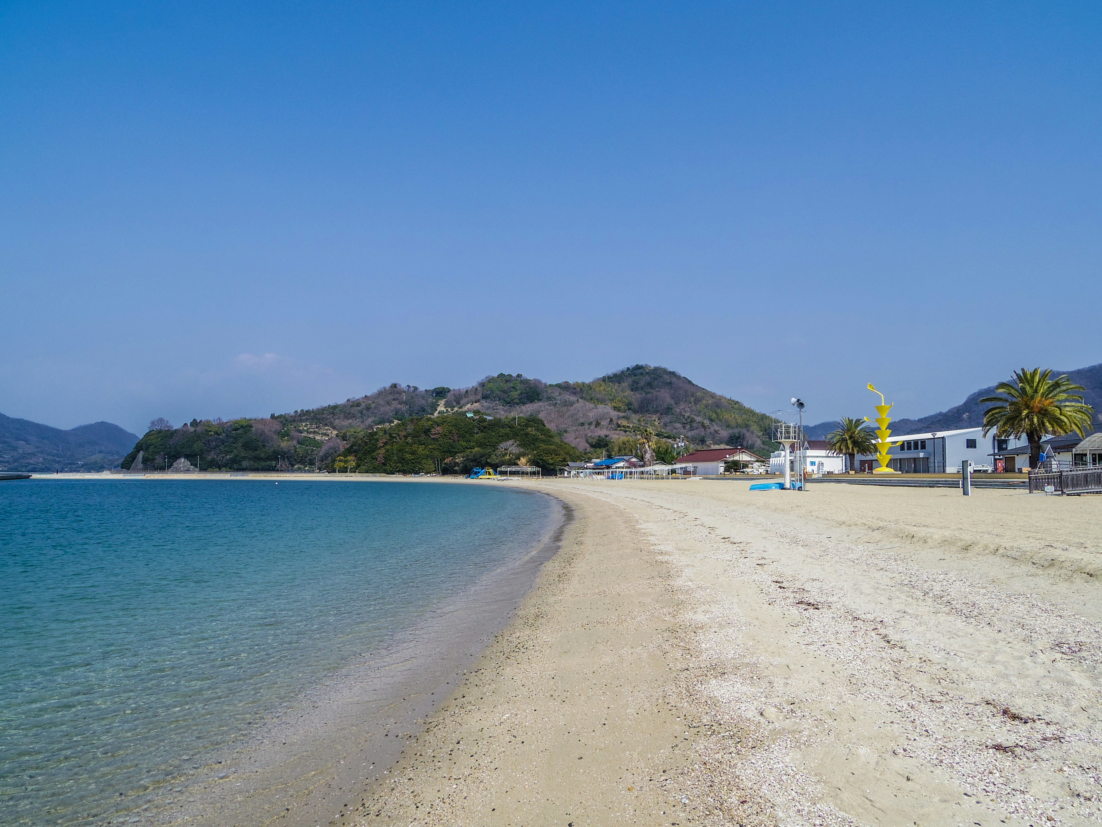 Vista panoramica di una spiaggia con acqua blu e riva sabbiosa