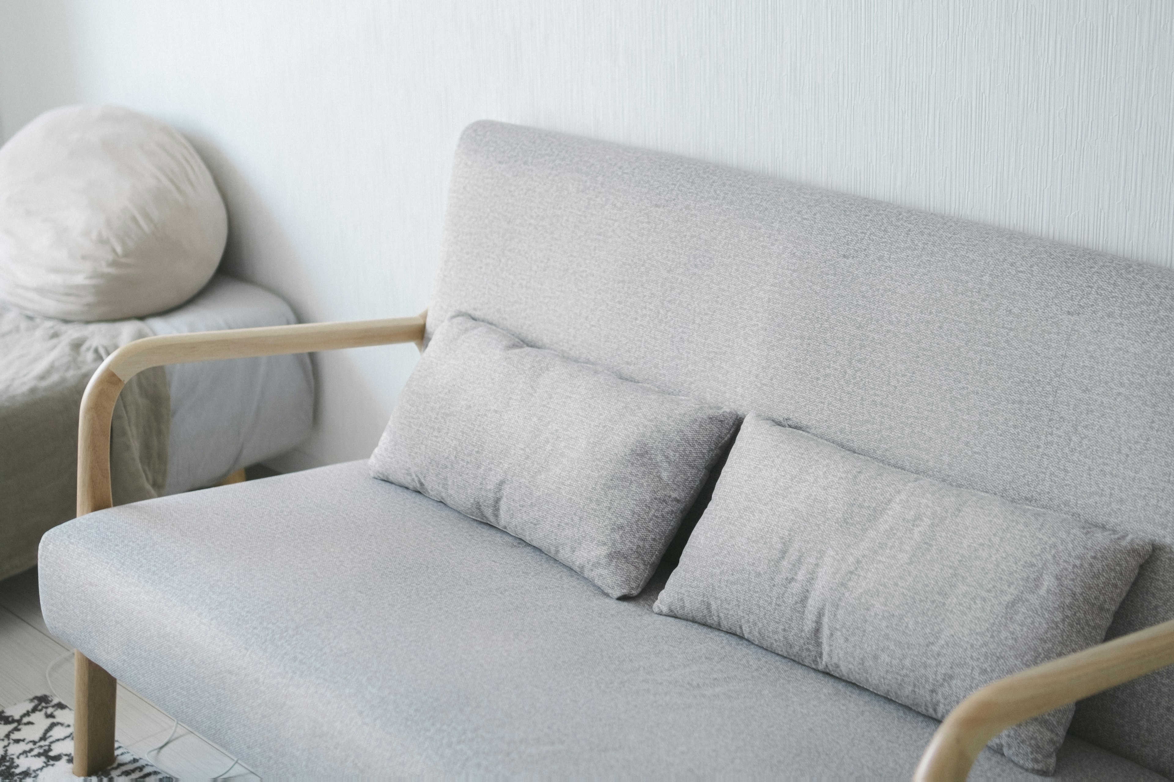 Un salon simple avec un canapé gris doux et des coussins