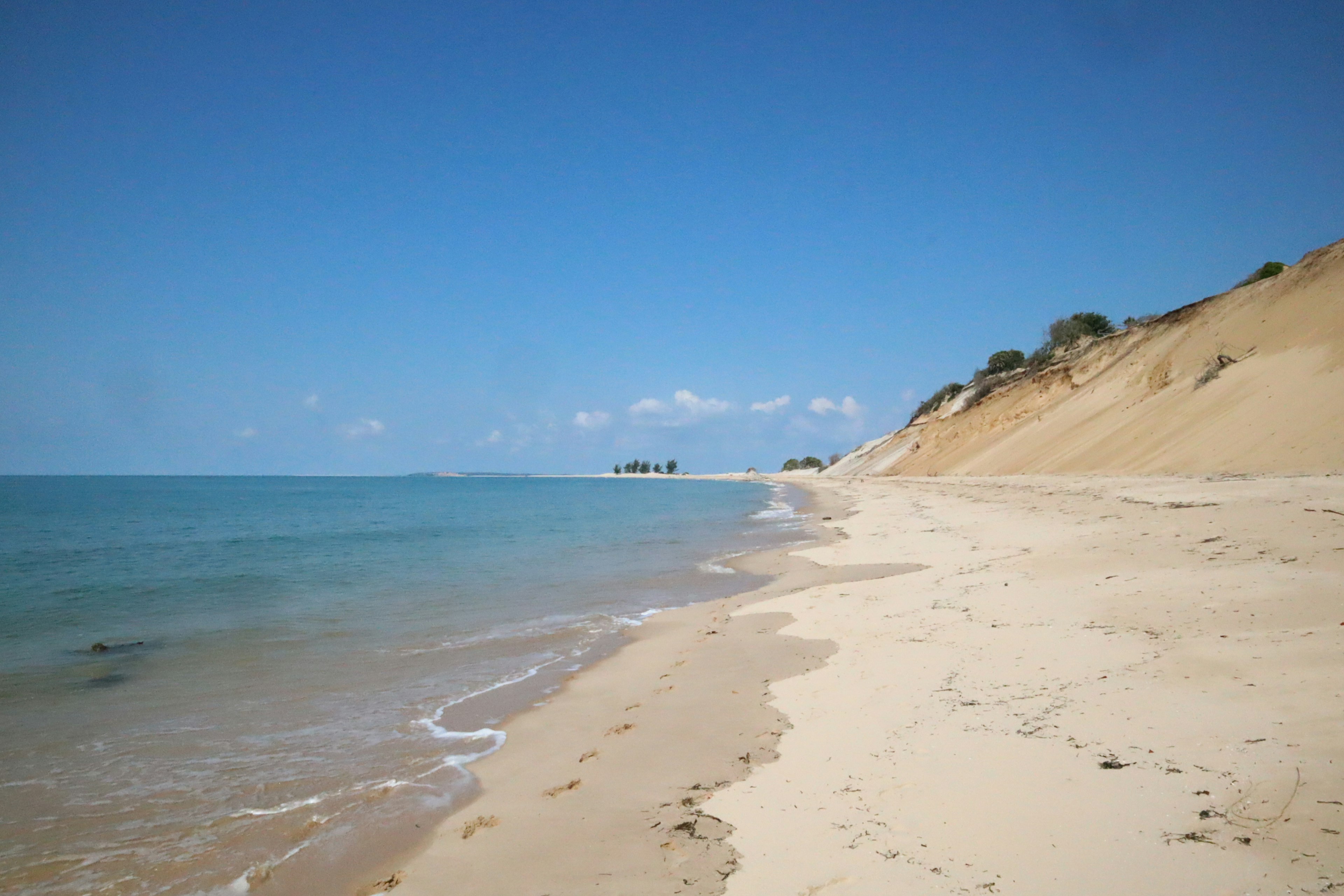 ชายหาดที่สวยงามพร้อมท้องฟ้าสีฟ้าและทะเลสงบ