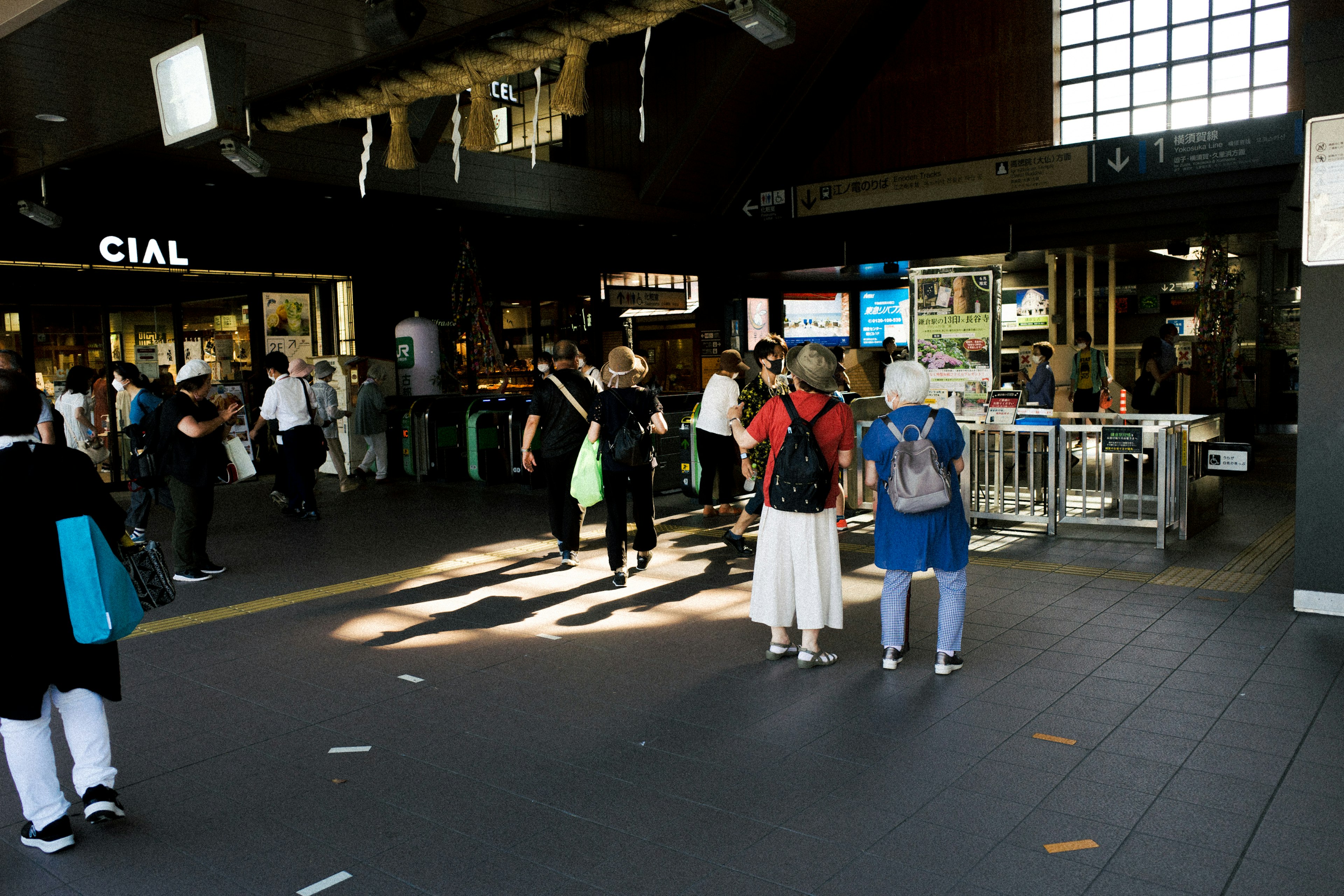 Busy interior of a train station with people walking and casual clothing